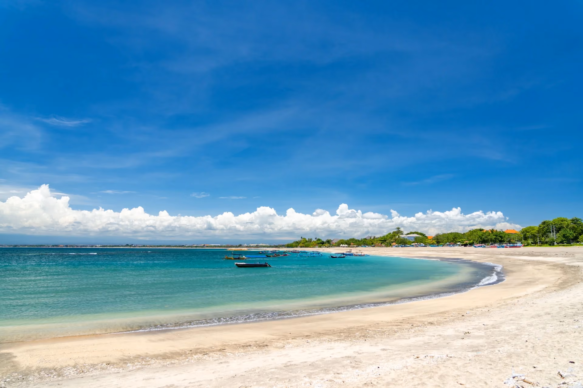 Energetic surf waves and lively crowds at Bali’s famous Kuta Beach.