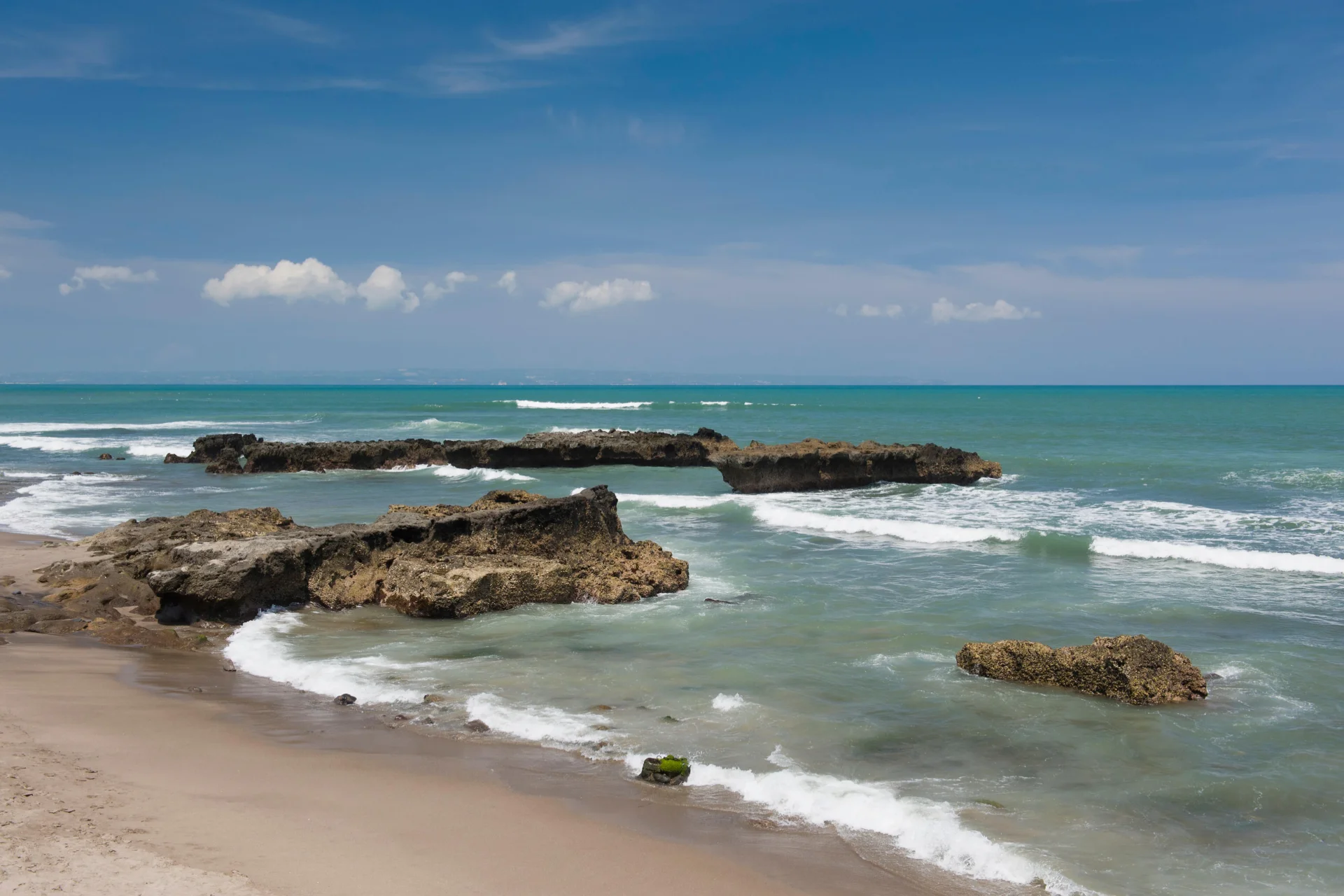 Soft waves and relaxed beachfront scene at Legian Beach near Kuta.