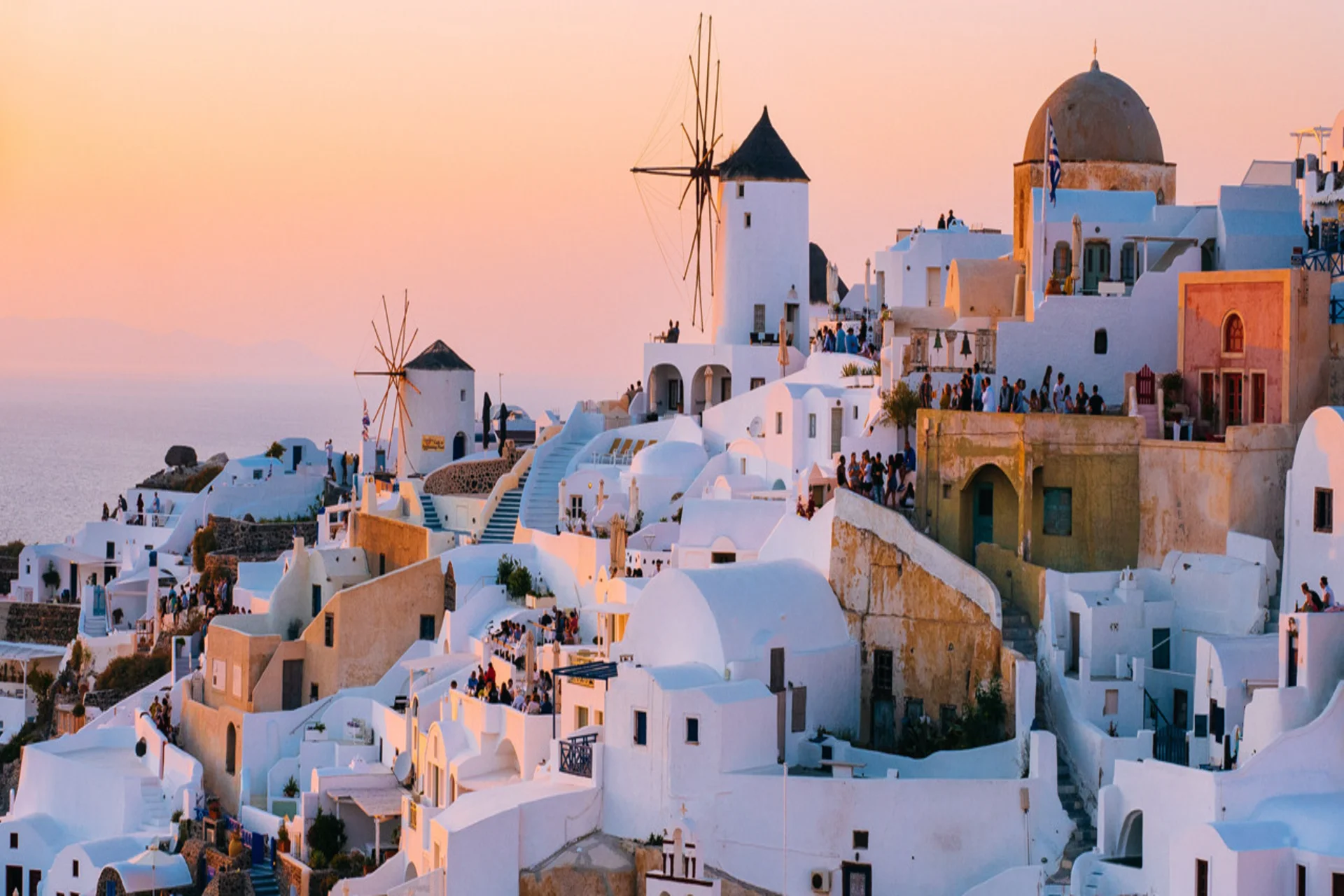 Greece Santorini white buildings and blue sea - best destination to visit in June for island hopping