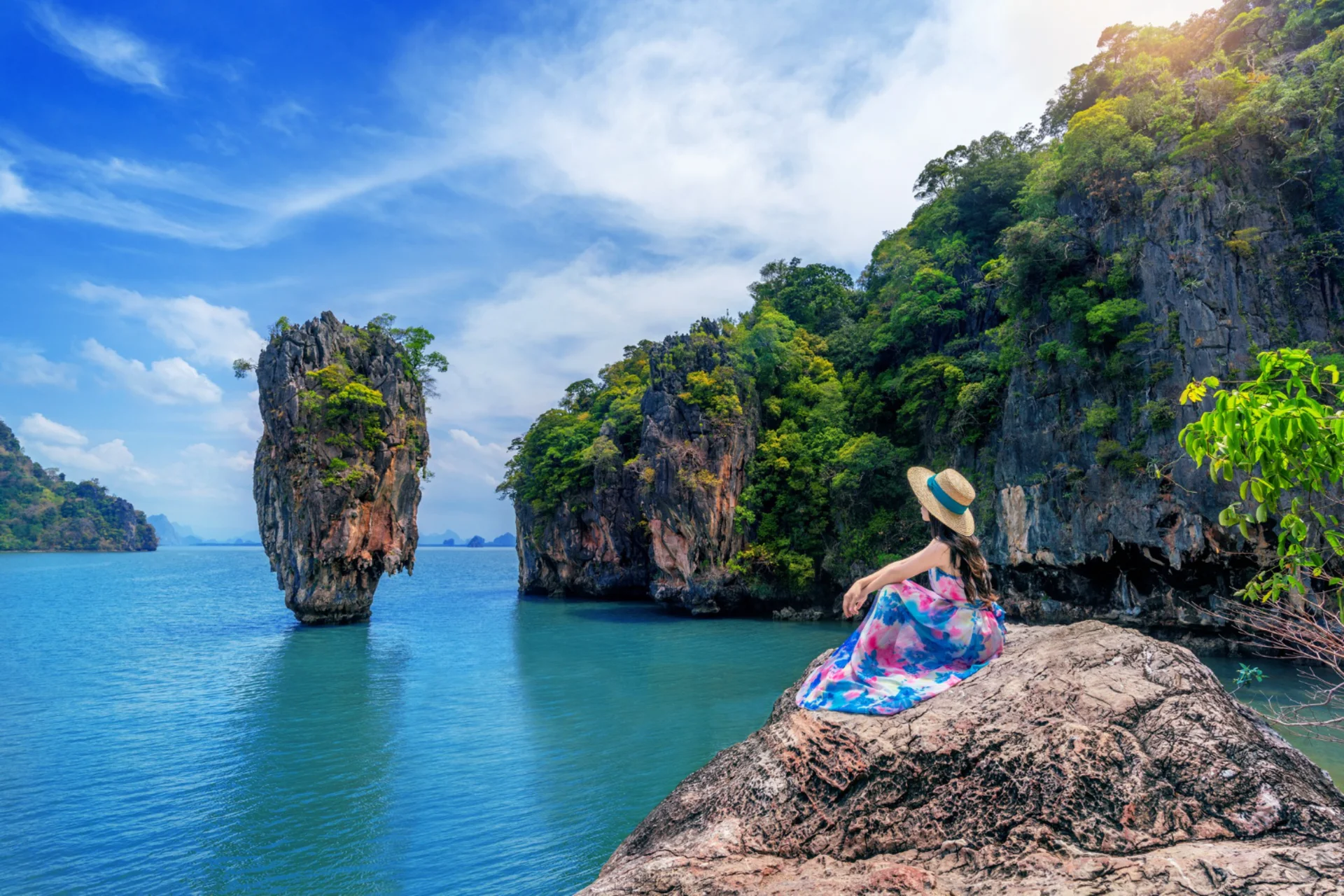 Woman sitting on rock overlooking limestone cliffs in Krabi, Thailand — Thailand vs UAE beach comparison