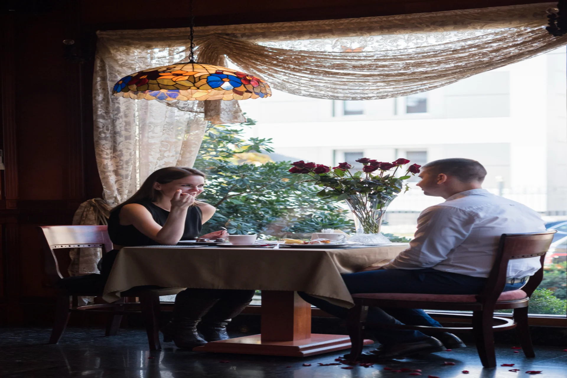  Couple dining at elegant restaurant table with roses and Tiffany lamp, Mauritius café hopping coastal dining