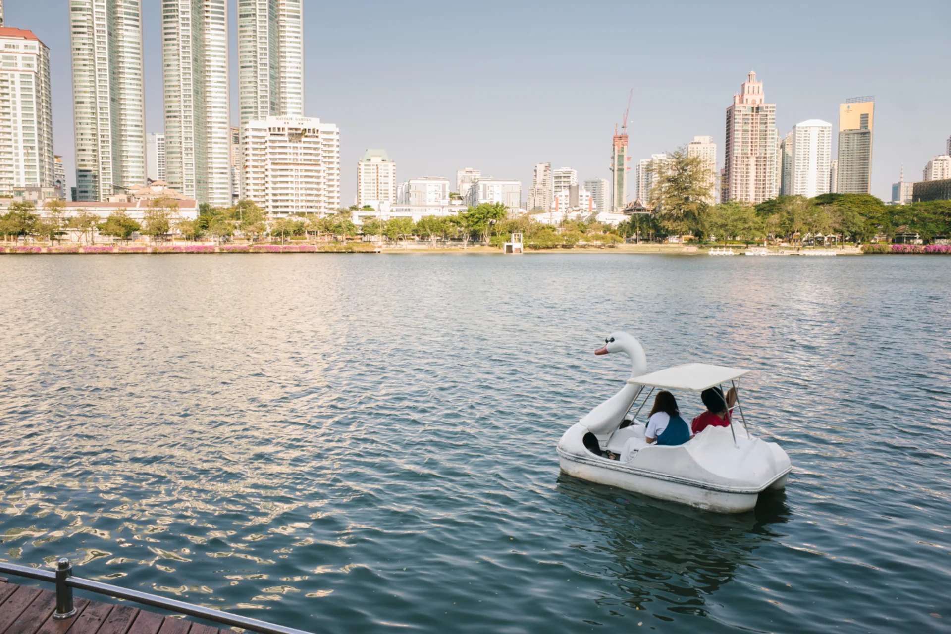 City exploration in Singapore and Dubai — couple on swan boat with urban skyline