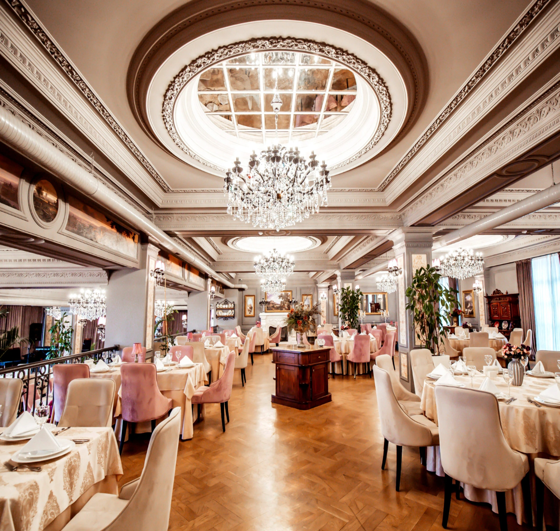 Elegant dining hall with crystal chandeliers and pink chairs — luxury restaurant Georgia vs Azerbaijan