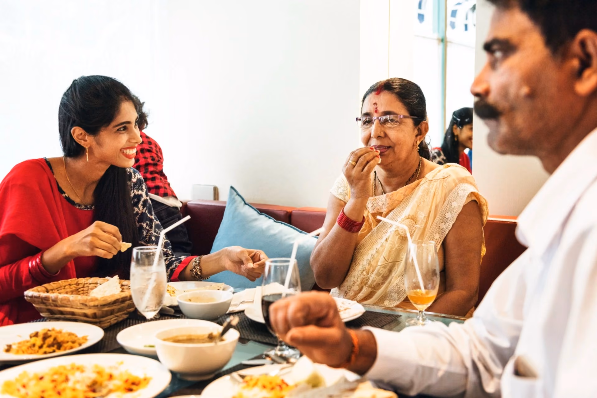Indian family dining at a restaurant in New Zealand vs Switzerland travel comparison