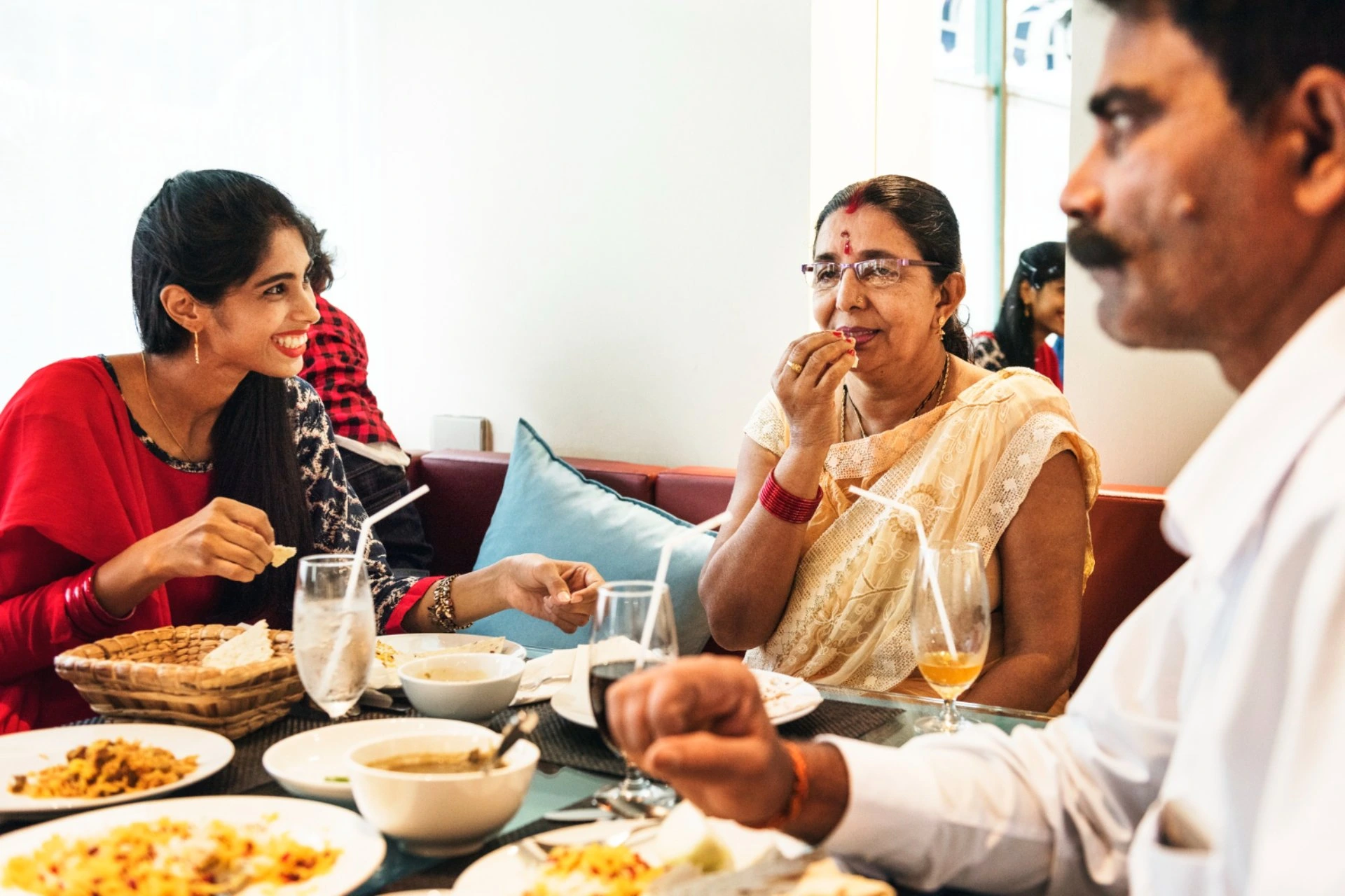 Indian family dining at a restaurant in New Zealand vs Switzerland travel comparison