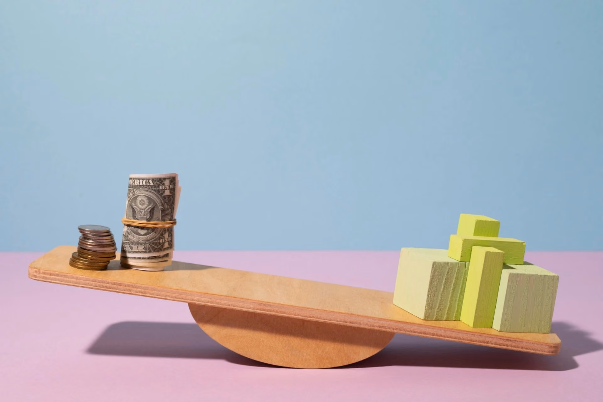 Balance scale with money and blocks — daily spending comparison for New Zealand vs Switzerland