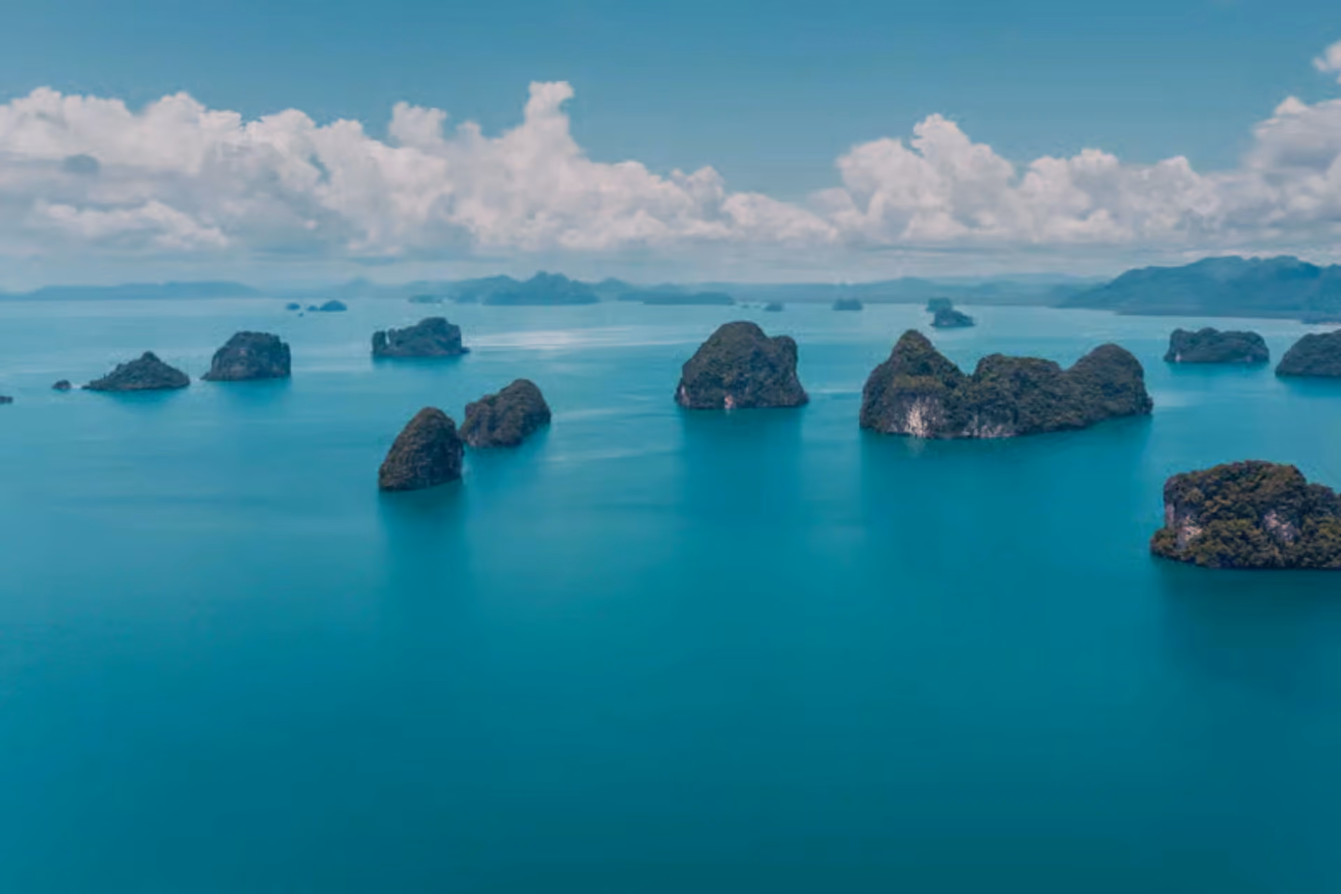 Rocky islands dotted in bright blue water at Ko Pak Bia