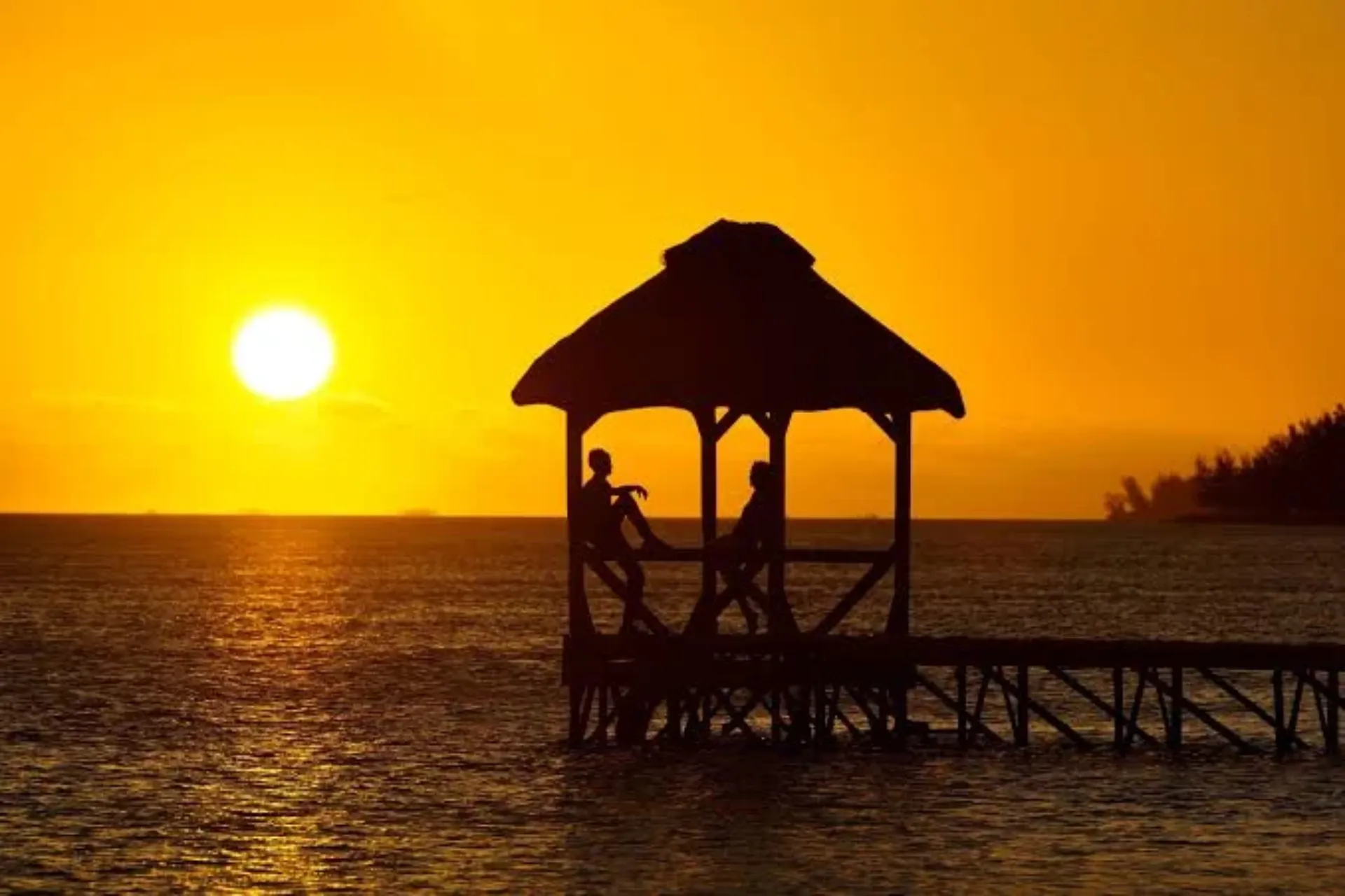 Couple in beach shelter at sunset, Mauritius