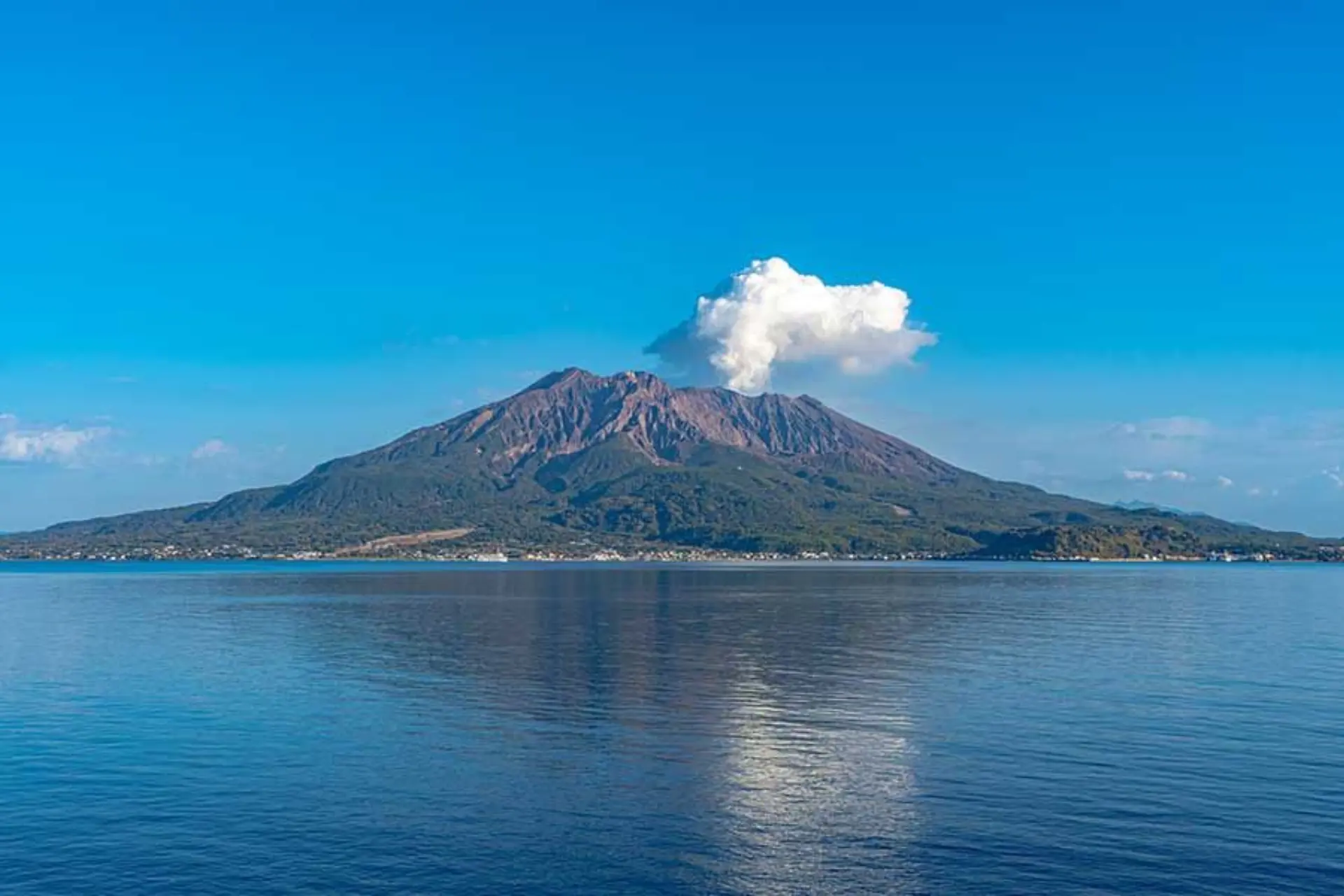 Volcano mountain rising from blue water in Bali Kintamani