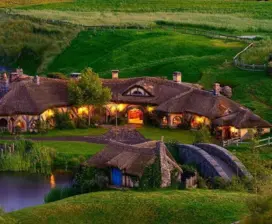 Hobbiton Movie Set homes built into green hillside at night