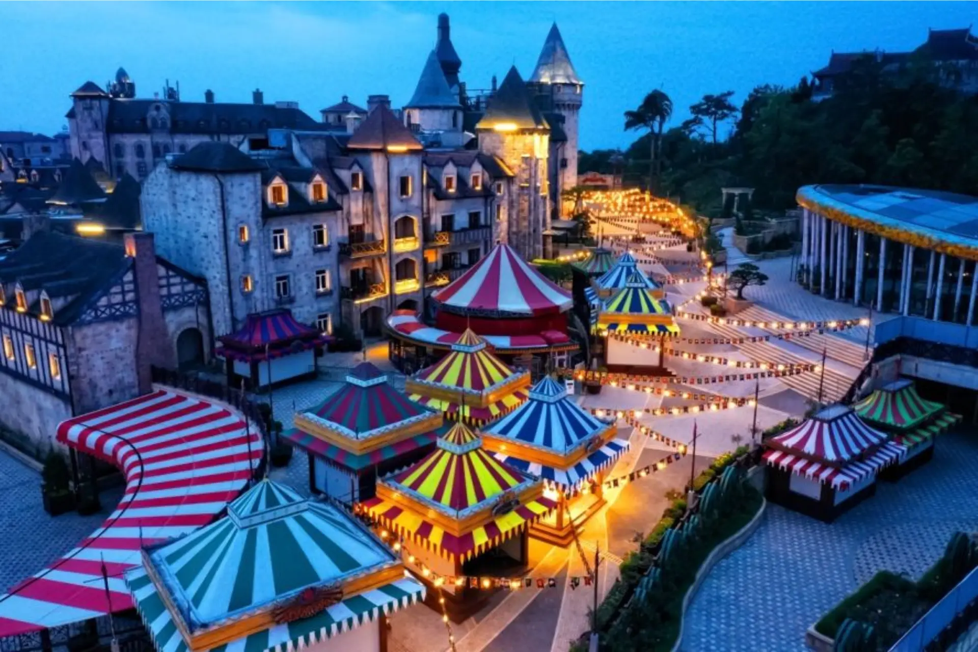 Fantasy Park Da Nang lit up at dusk with colorful circus tents