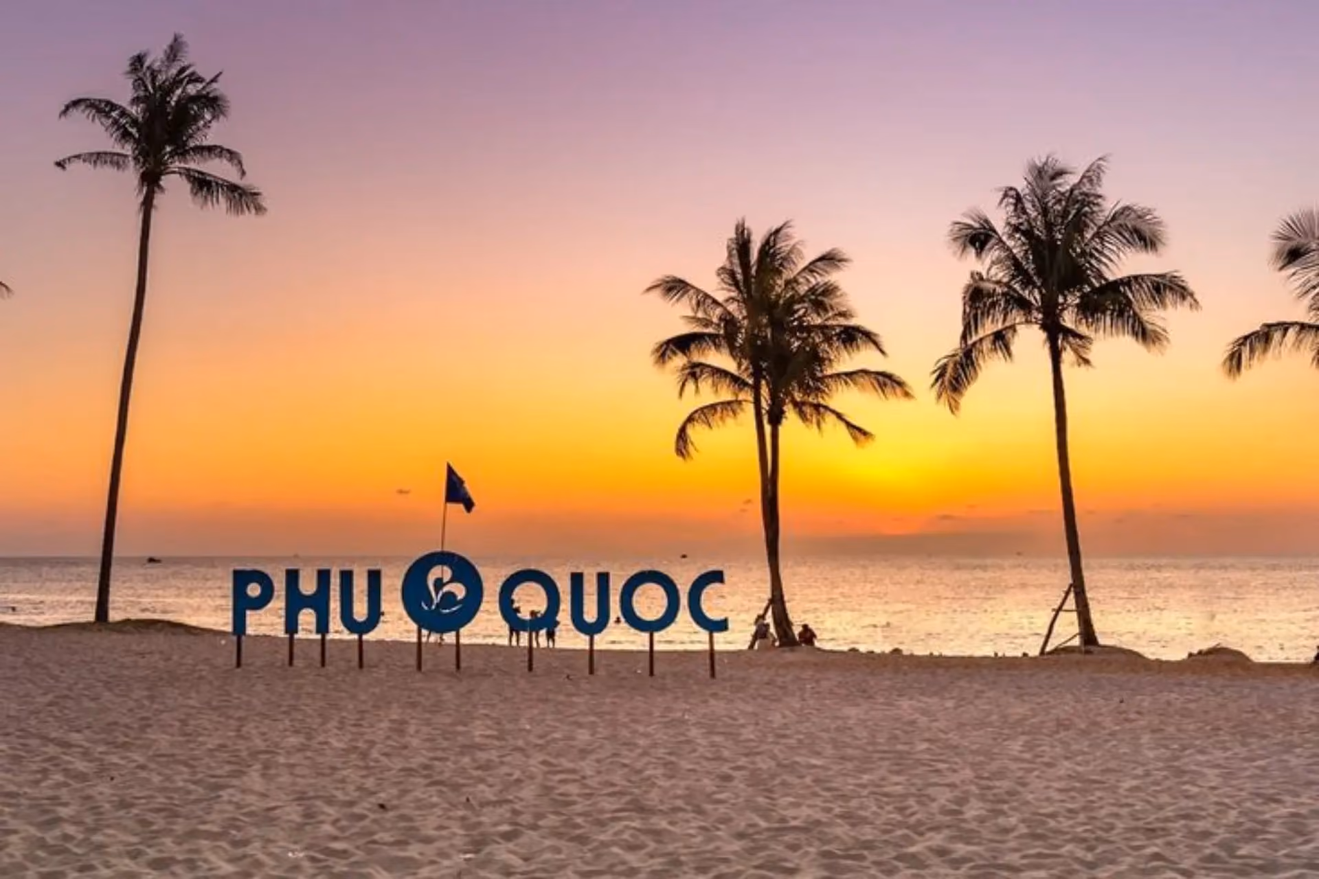 Phu Quoc sign on beach at sunset with palm trees