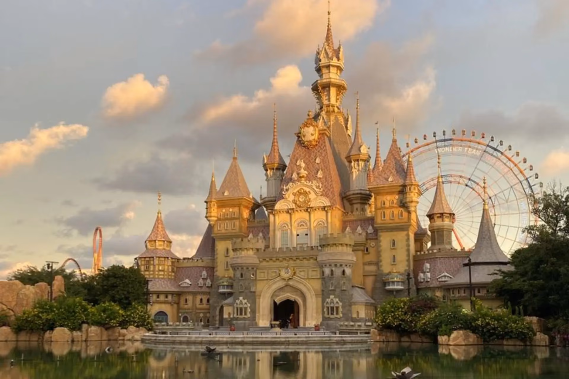 Golden castle with towers reflected in water at Vinwonders Vietnam