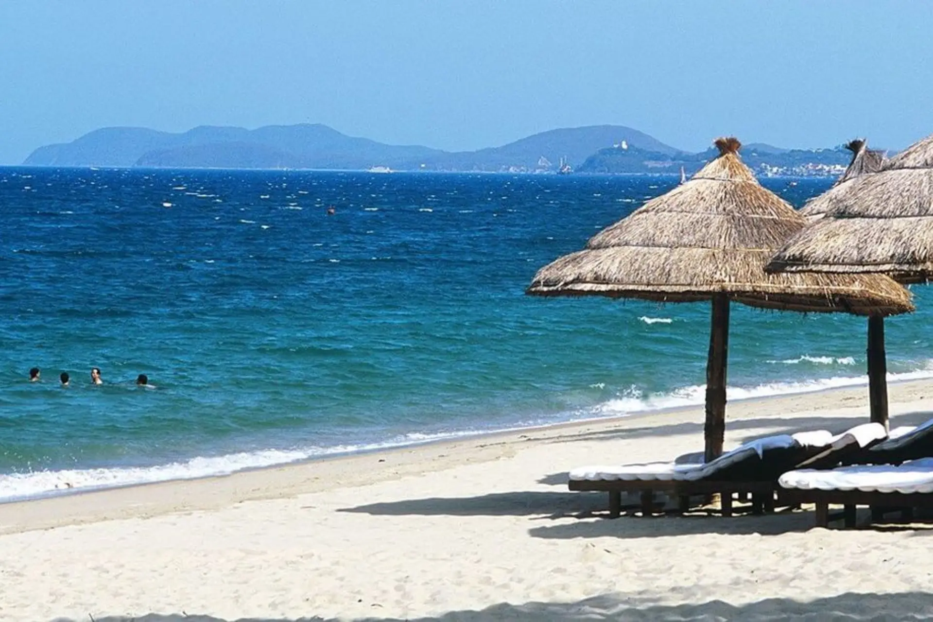 Thatched umbrellas and loungers on Nha Trang Beach Vietnam