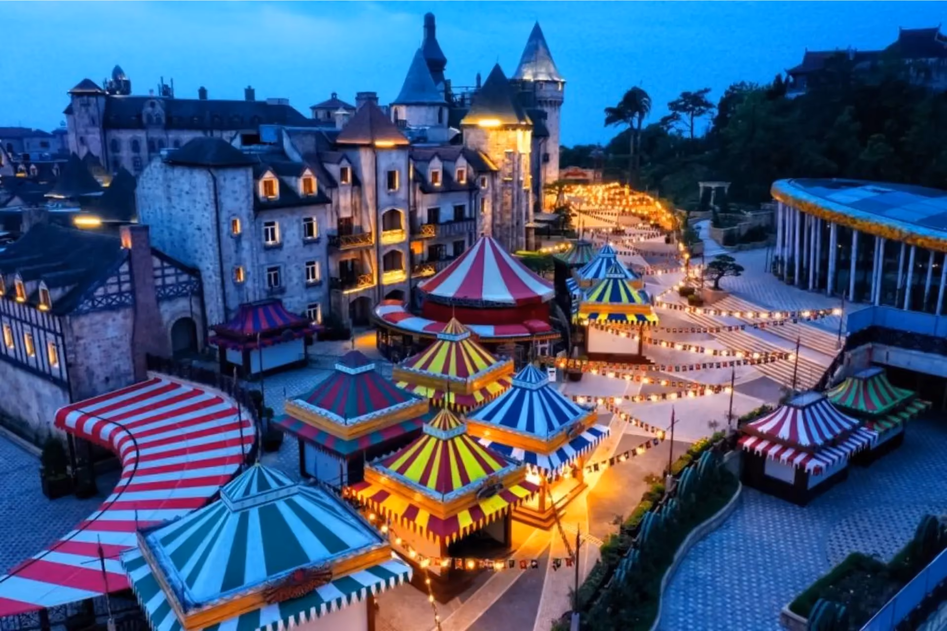 Fantasy Park Da Nang lit up at dusk with colorful circus tents