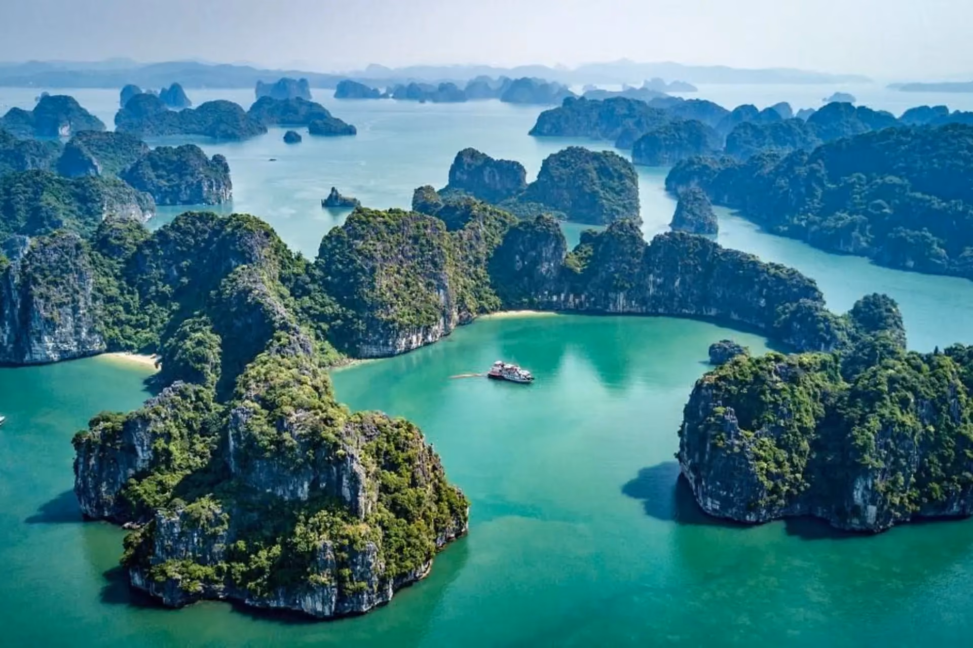 Limestone islands with green trees in blue-green water, Halong Bay Vietnam