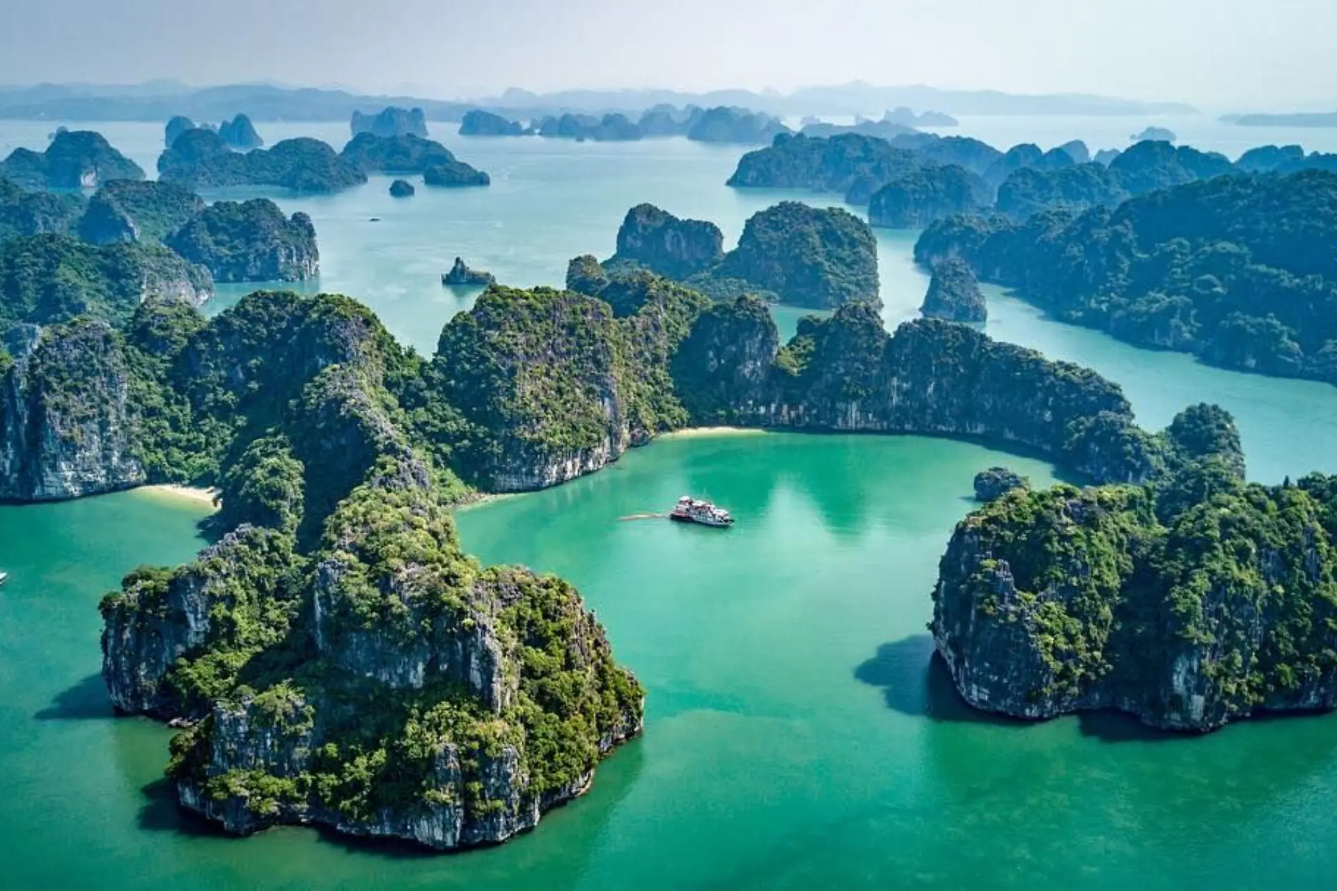 Limestone islands with green trees in blue-green water, Halong Bay Vietnam