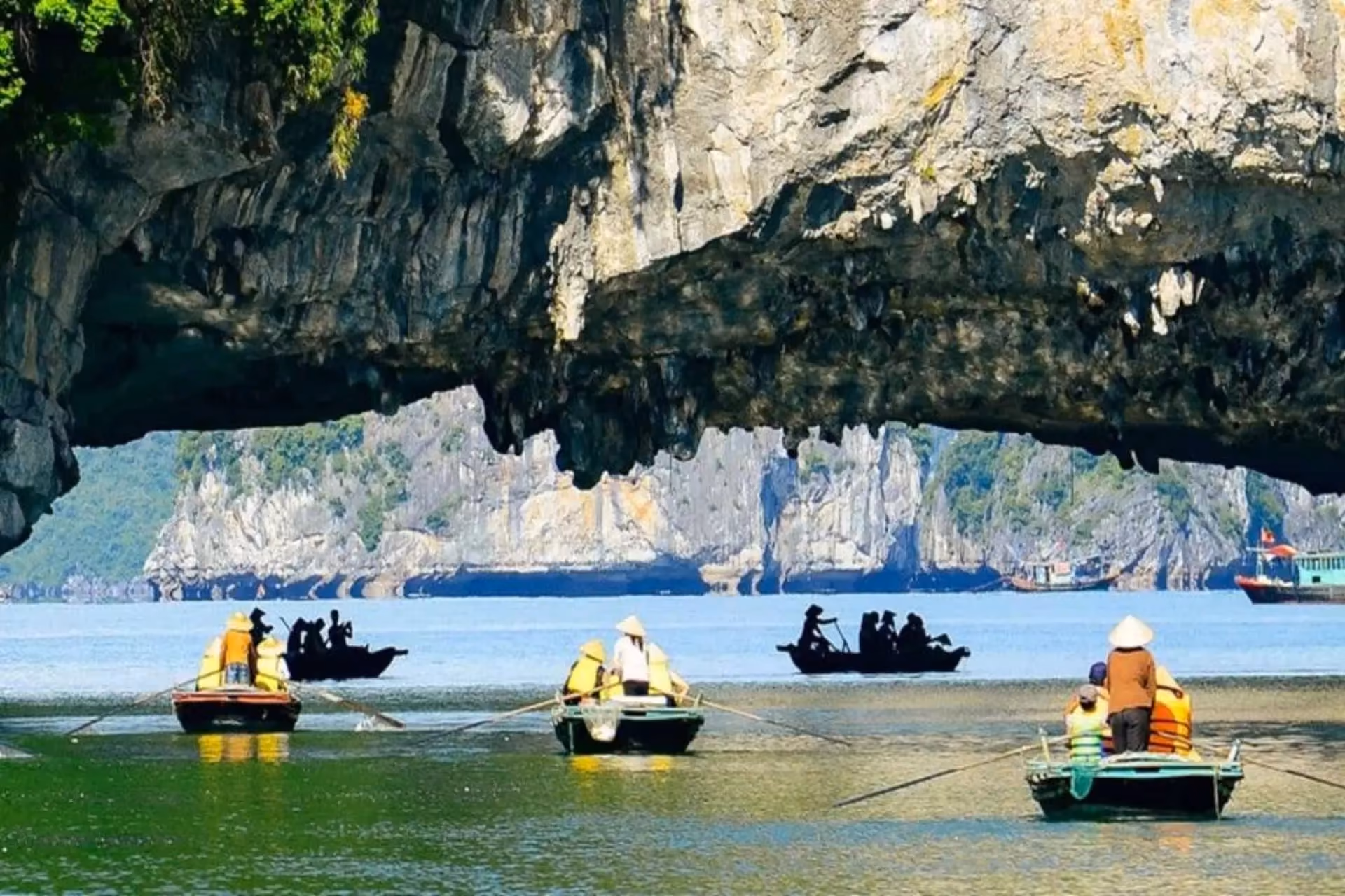 Boats with tourists near limestone cliffs in Halong Bay Vietnam