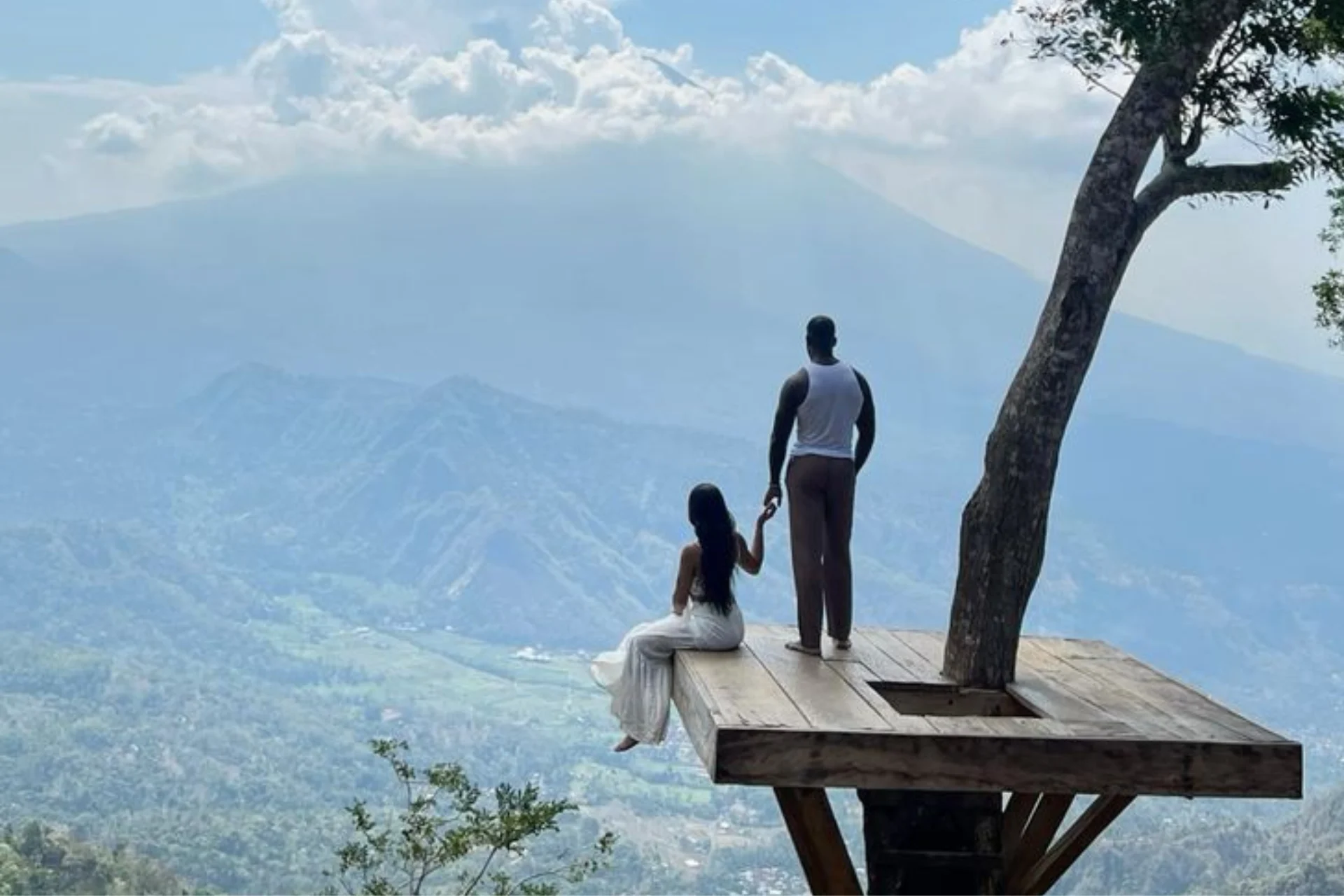 Two people on wooden platform at Lahangan Sweet Viewpoint overlooking mountains