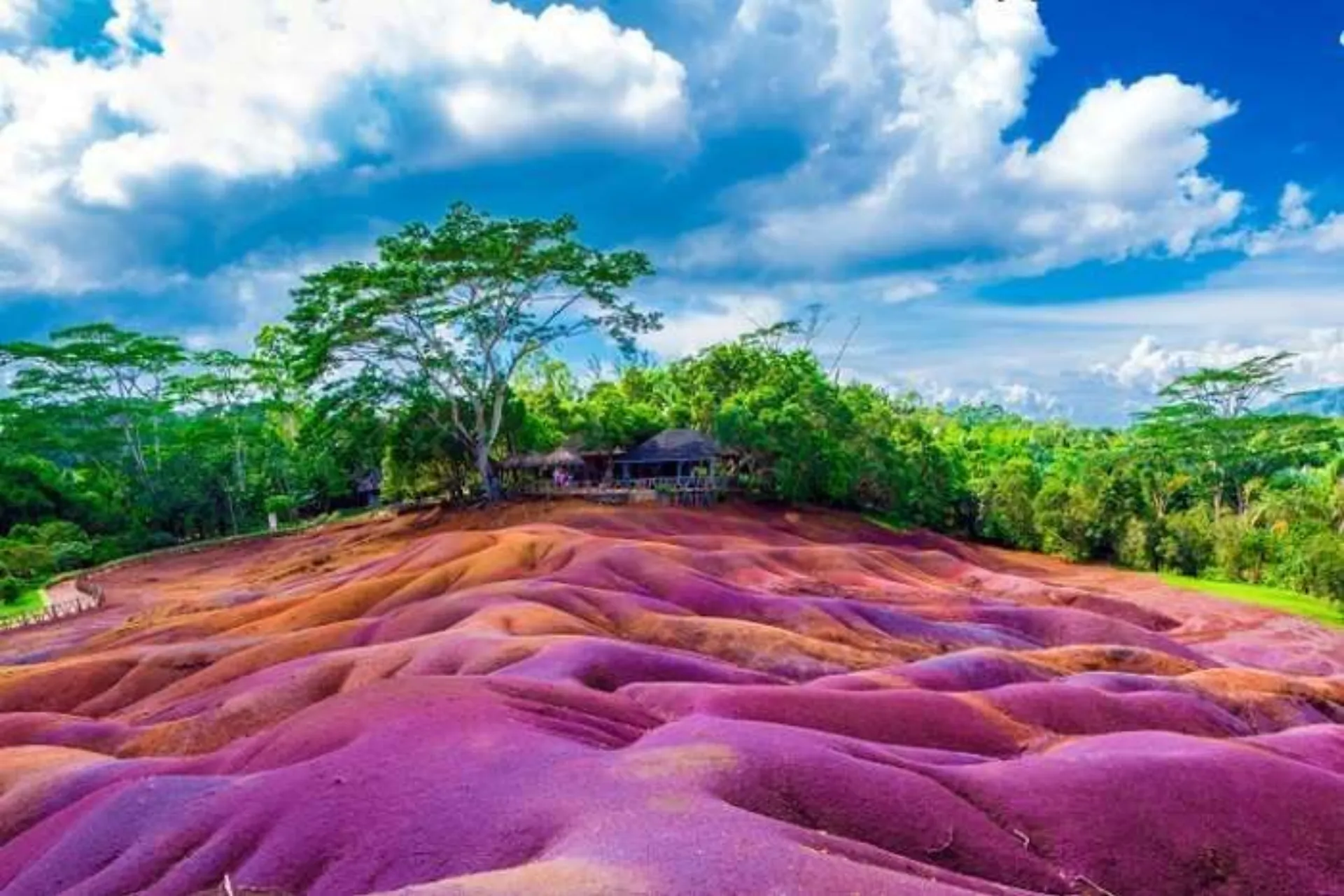 Colorful striped sand dunes in Mauritius with green trees