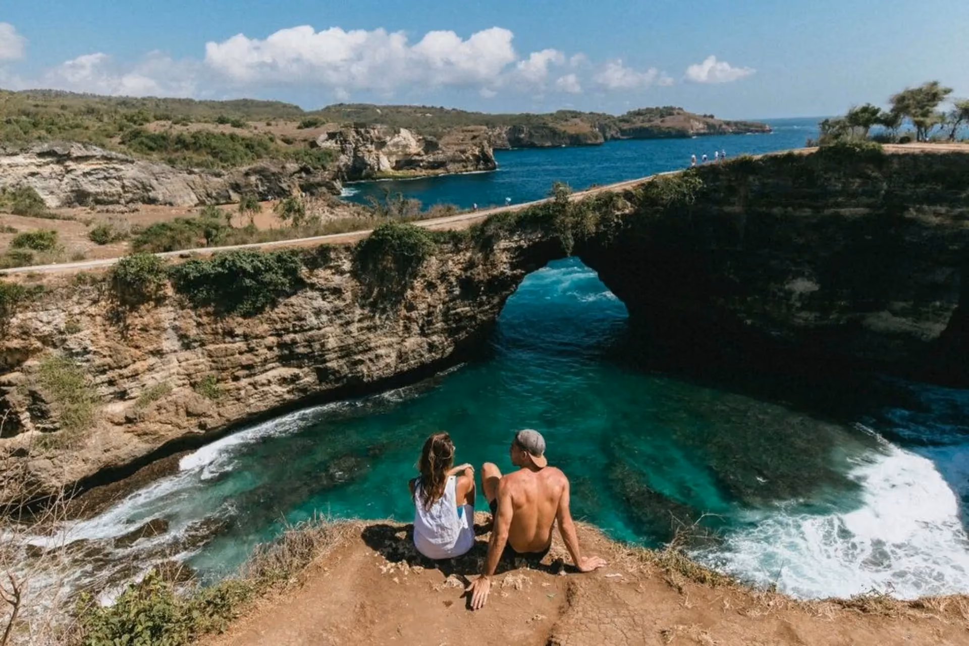 Two people sitting on cliff edge at Angel's Billabong Bali