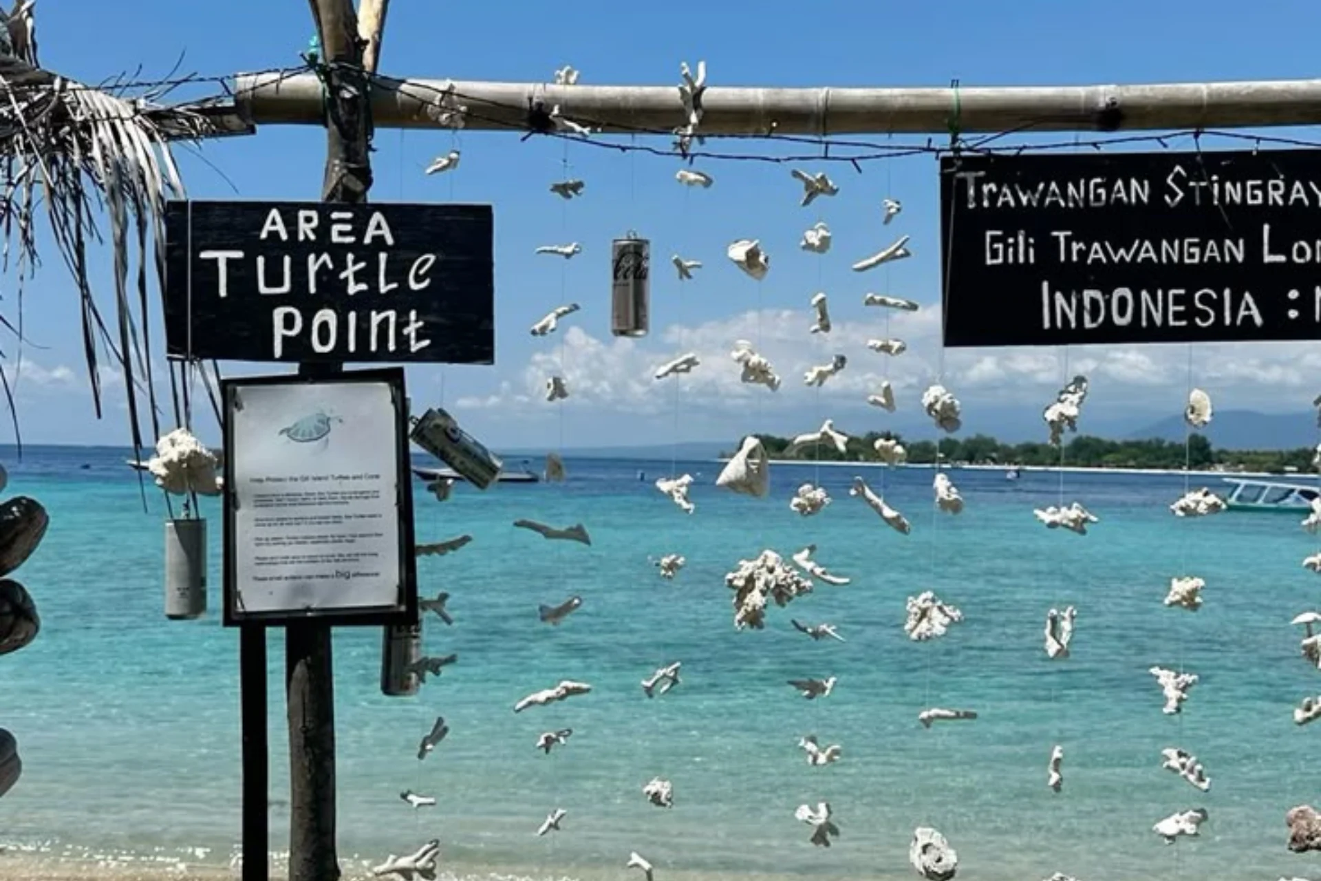 Turtle Point sign with swimmers in clear water, Gili Trawangan