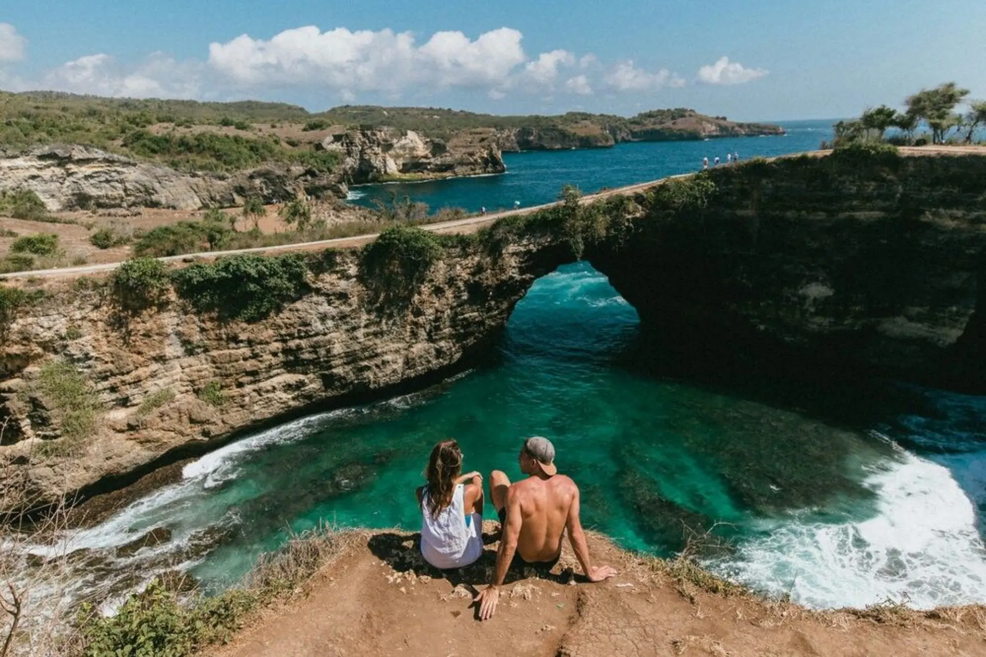 Two people sitting on cliff edge at Angel's Billabong Bali