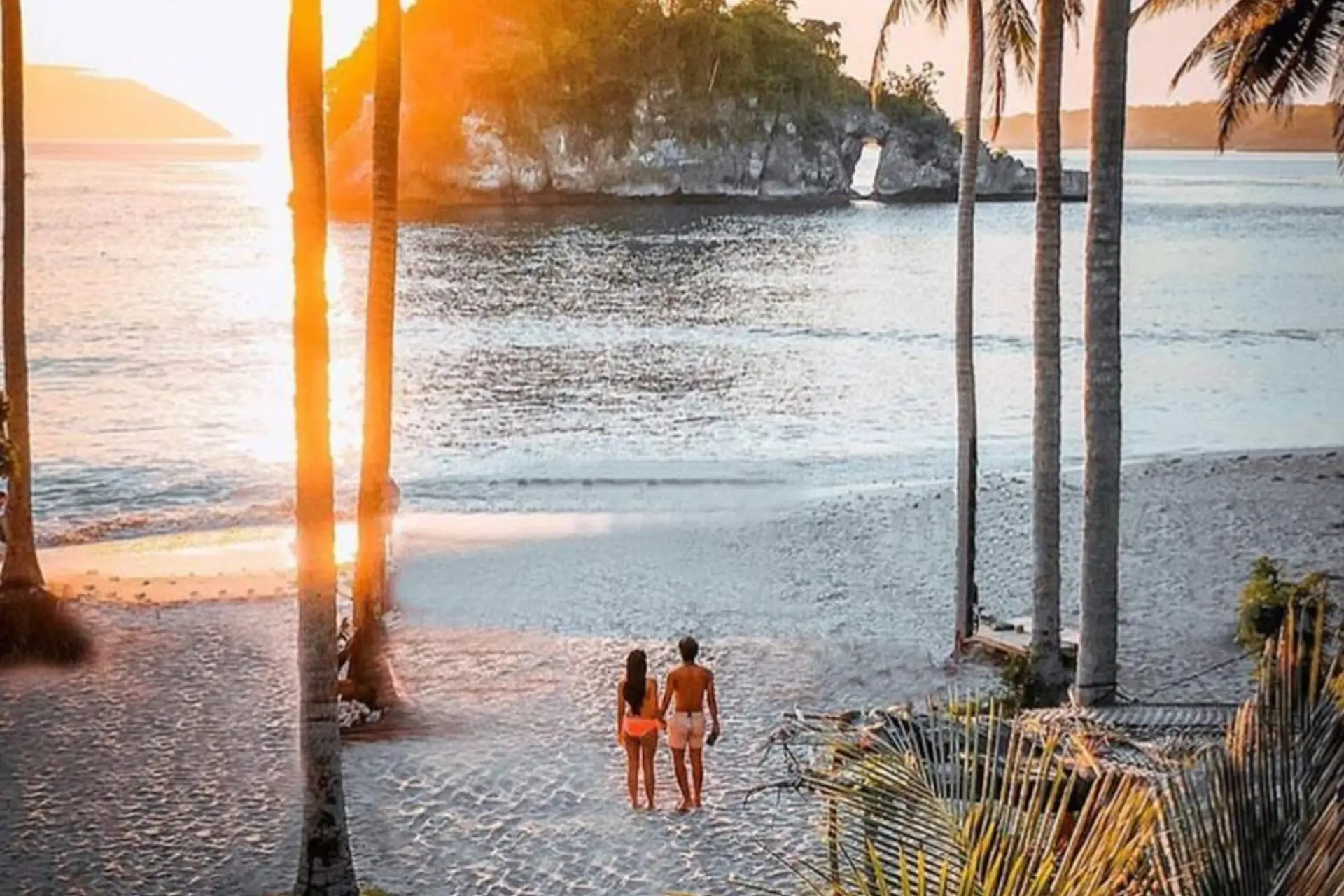 Two children standing on Bali beach at sunset