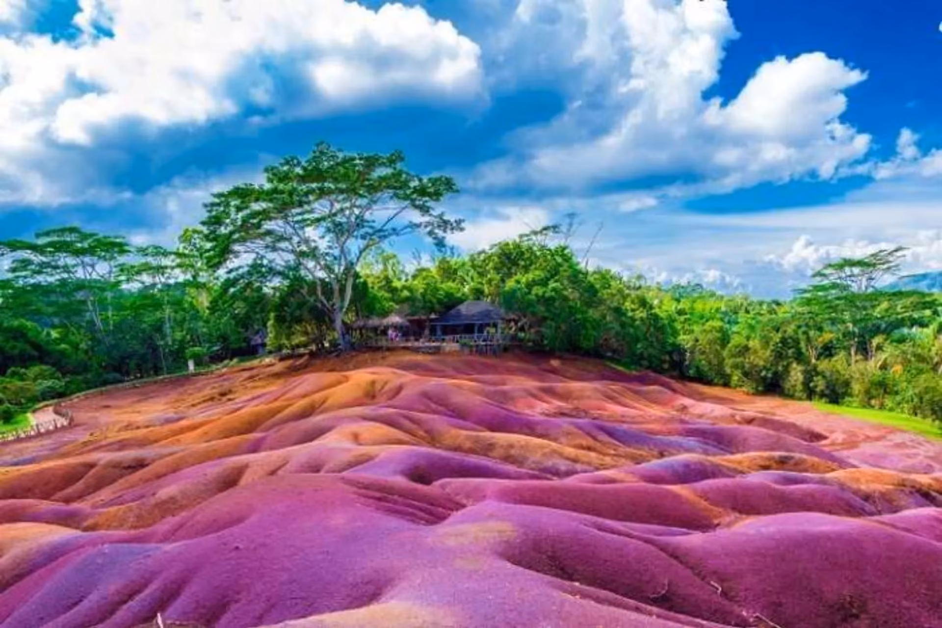 Colorful striped sand dunes in Mauritius with green trees
