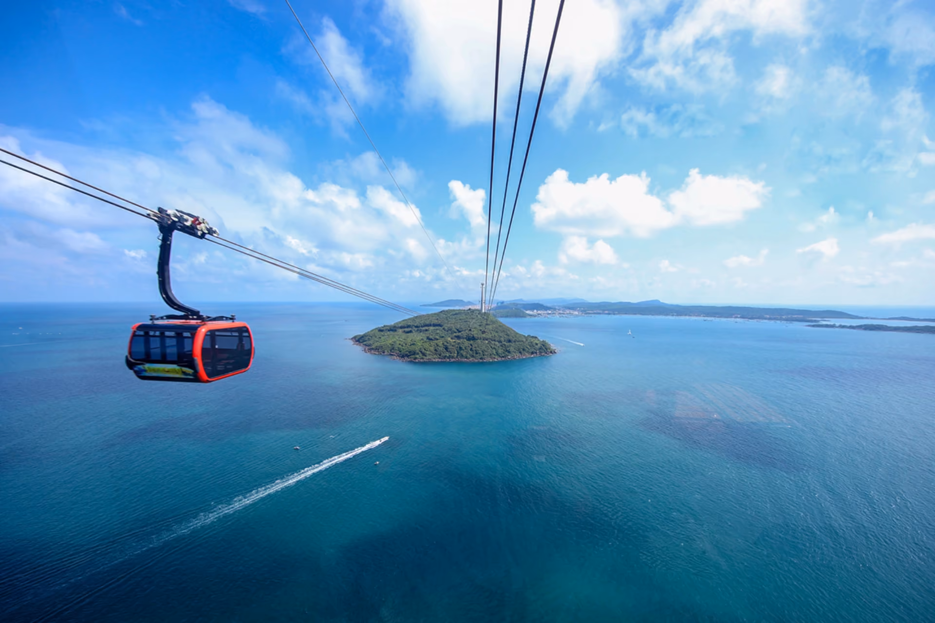 Red cable car over blue water and island, Phu Quoc