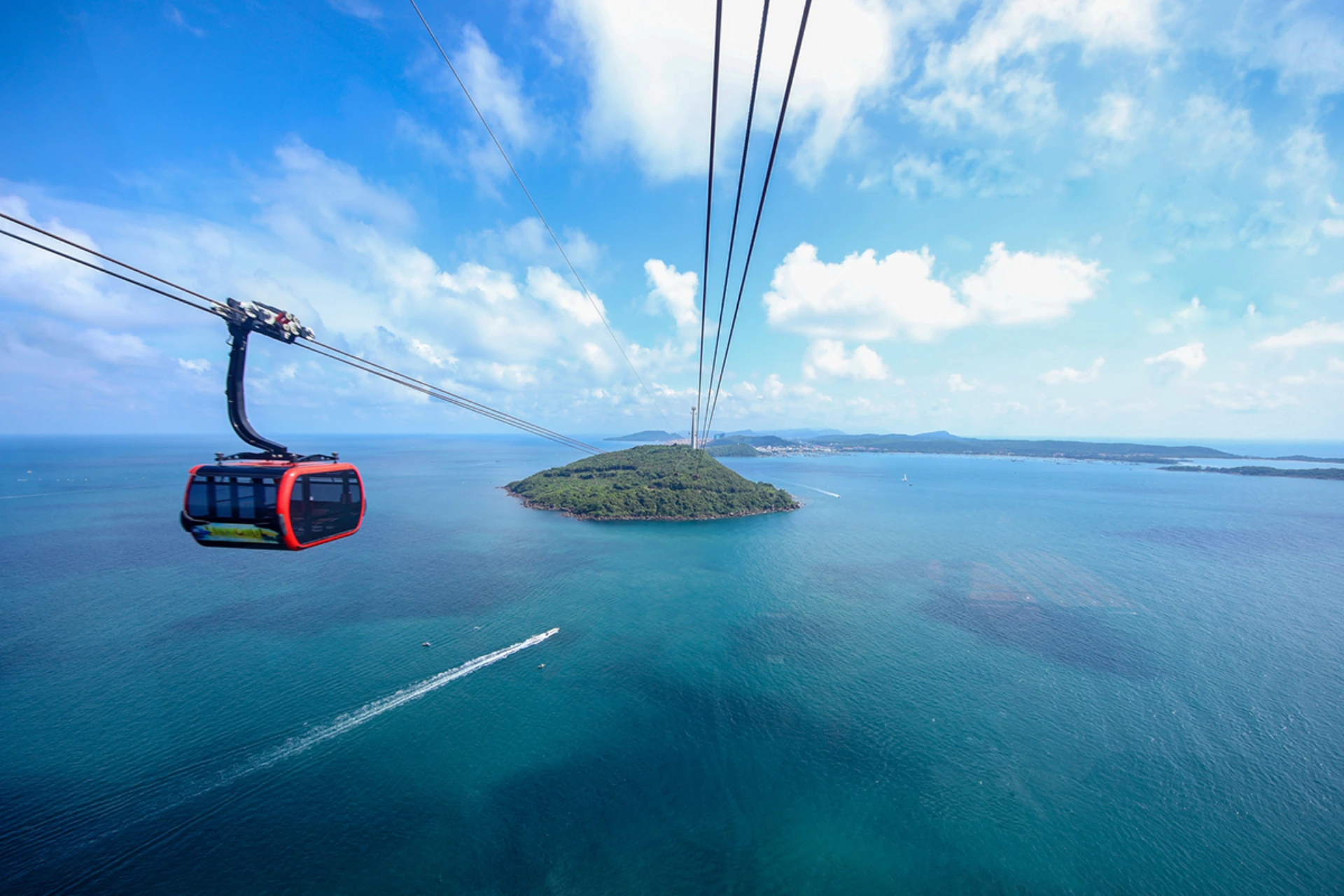 Red cable car over blue water and island, Phu Quoc