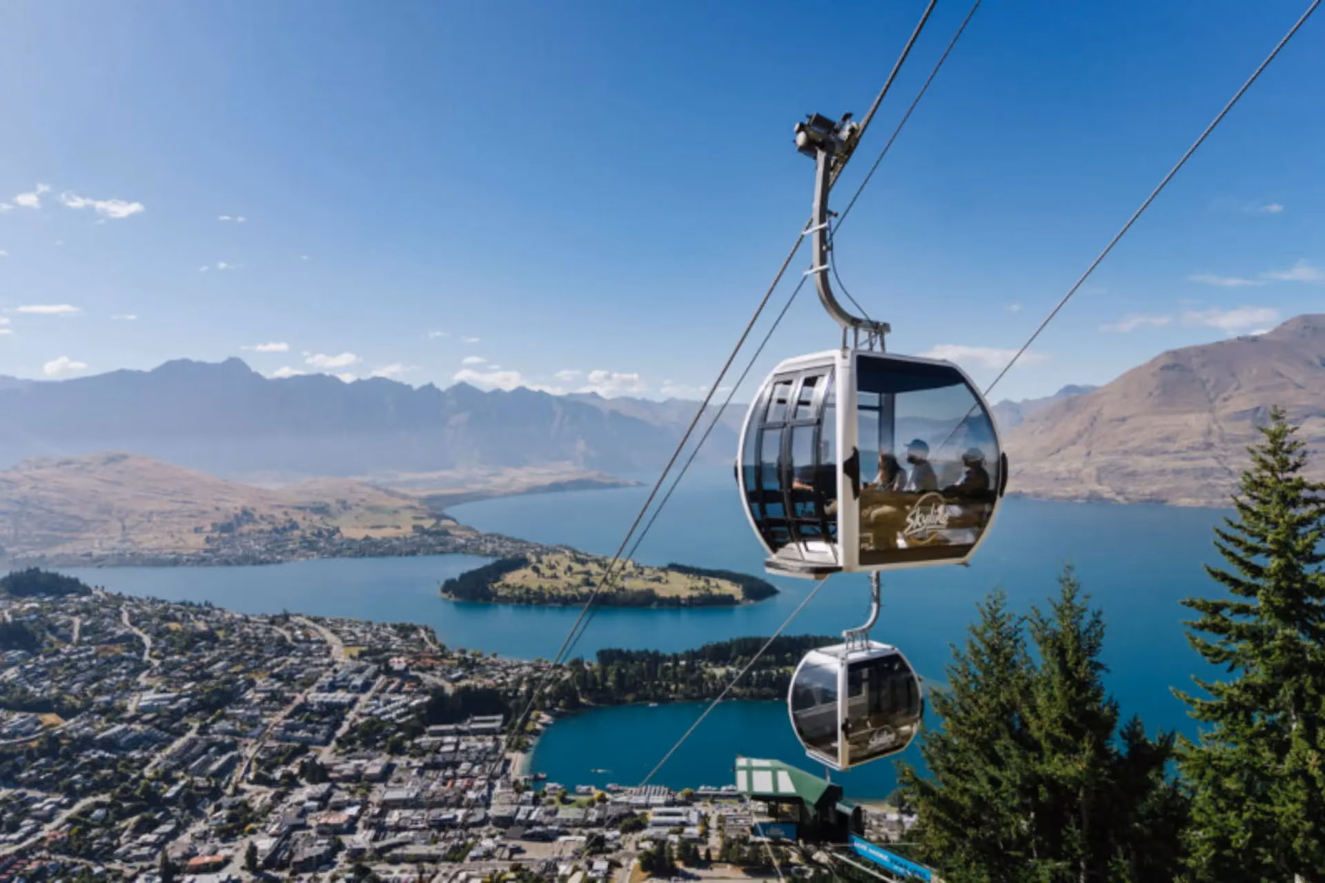 Gondola cabins above lake and mountains in Queenstown, New Zealand