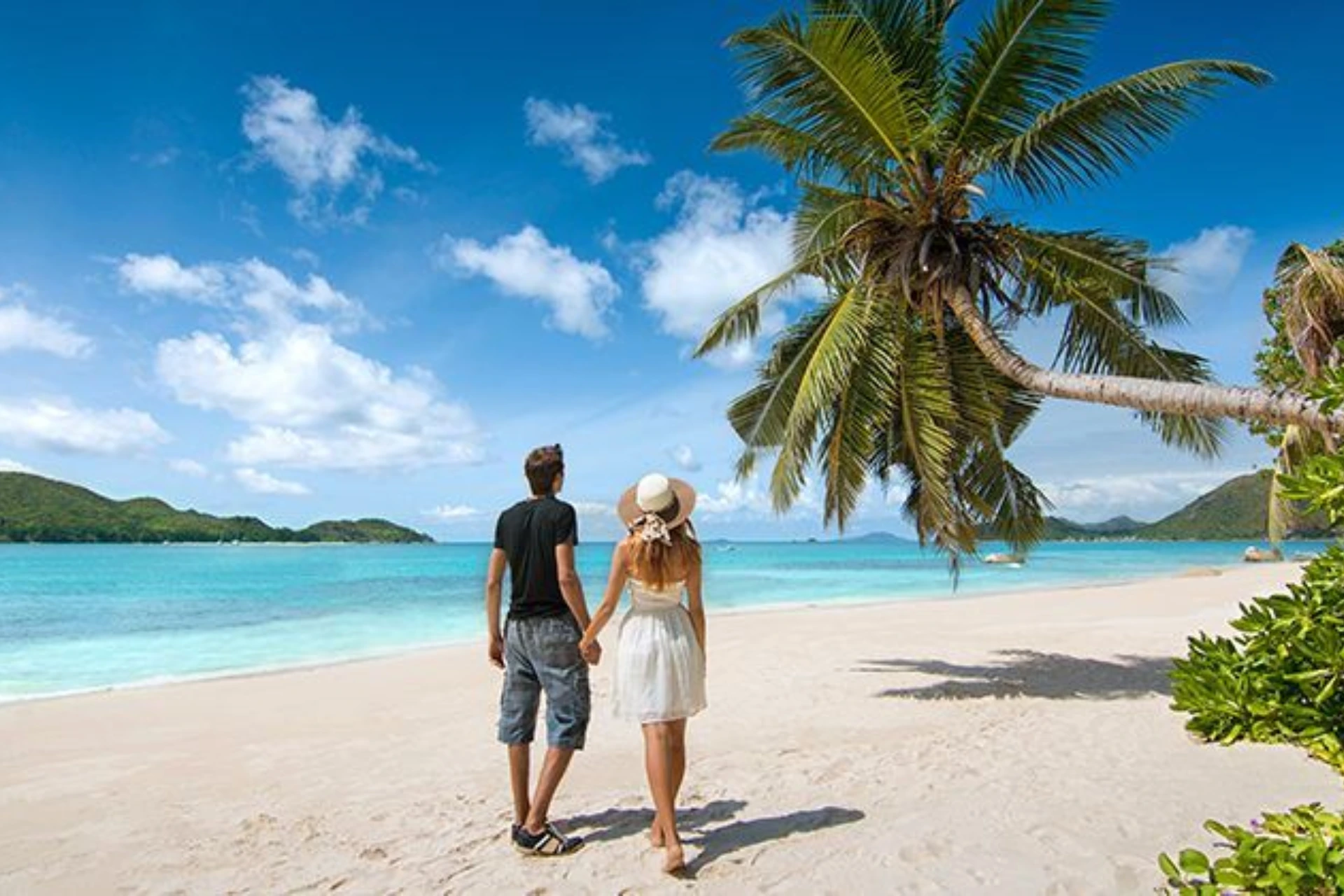 Couple holding hands on sandy beach in Mauritius
