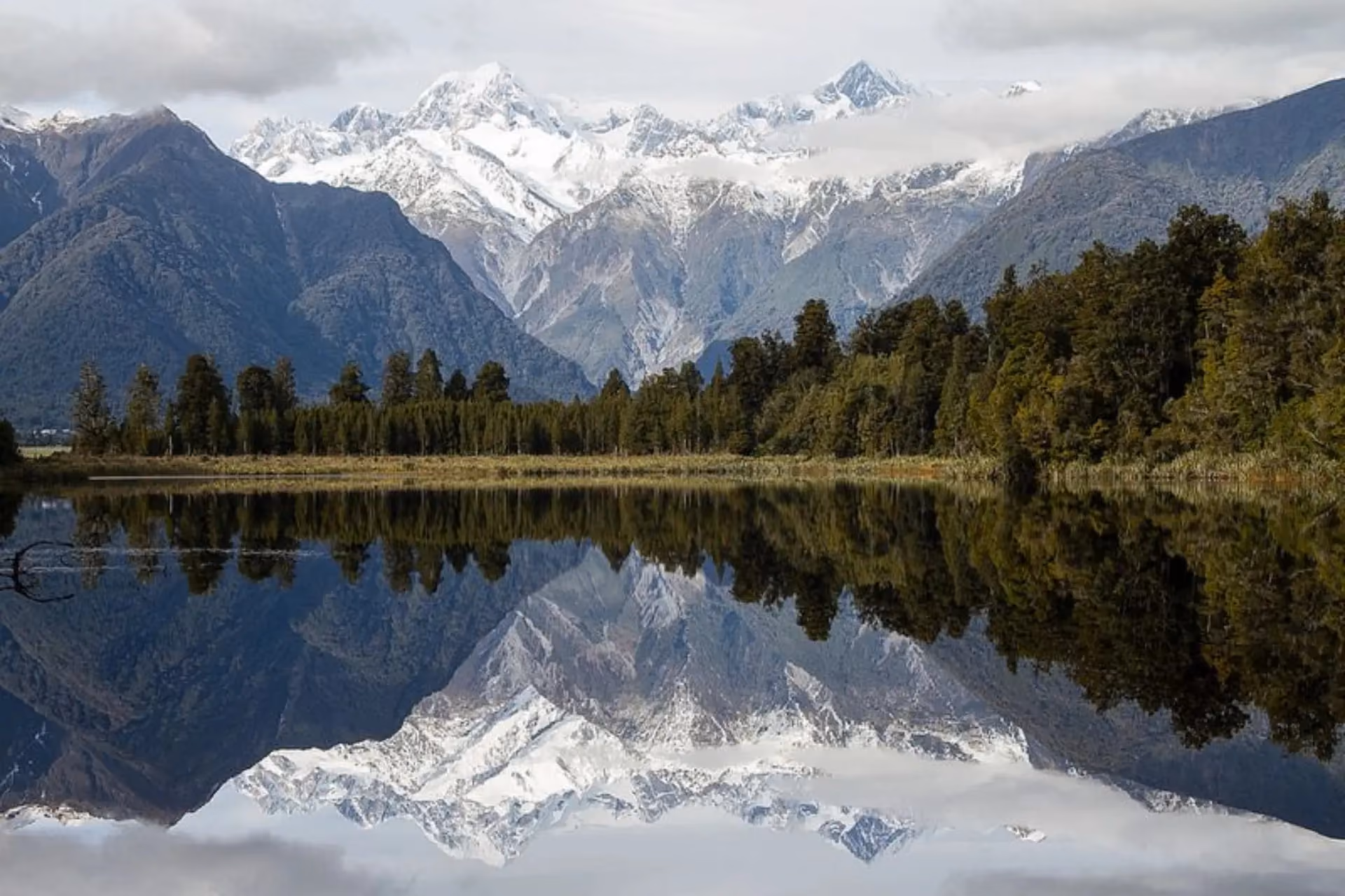 Snow mountains reflected in Mirror Lake New Zealand