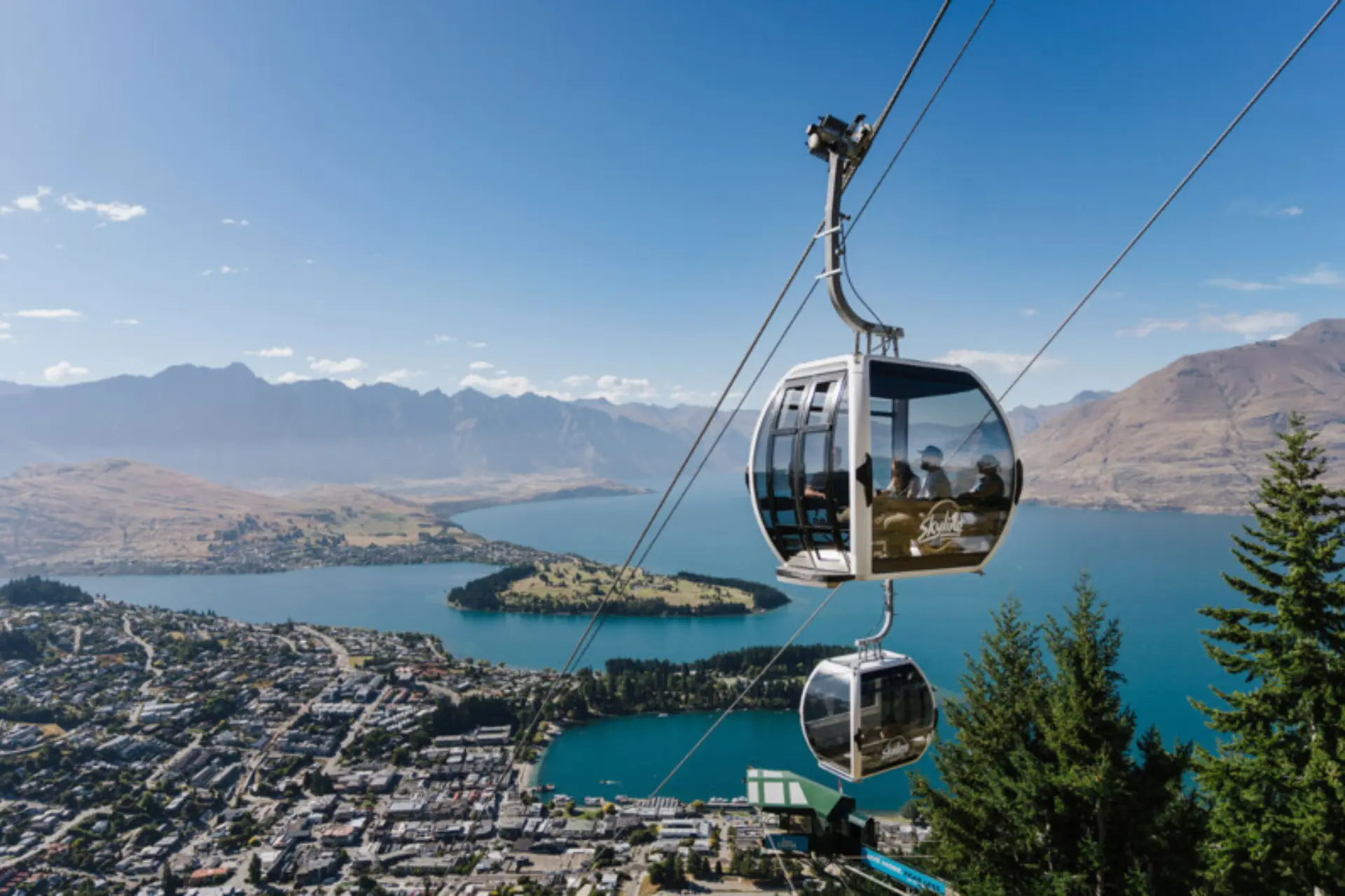 Gondola cabins above lake and mountains in Queenstown, New Zealand
