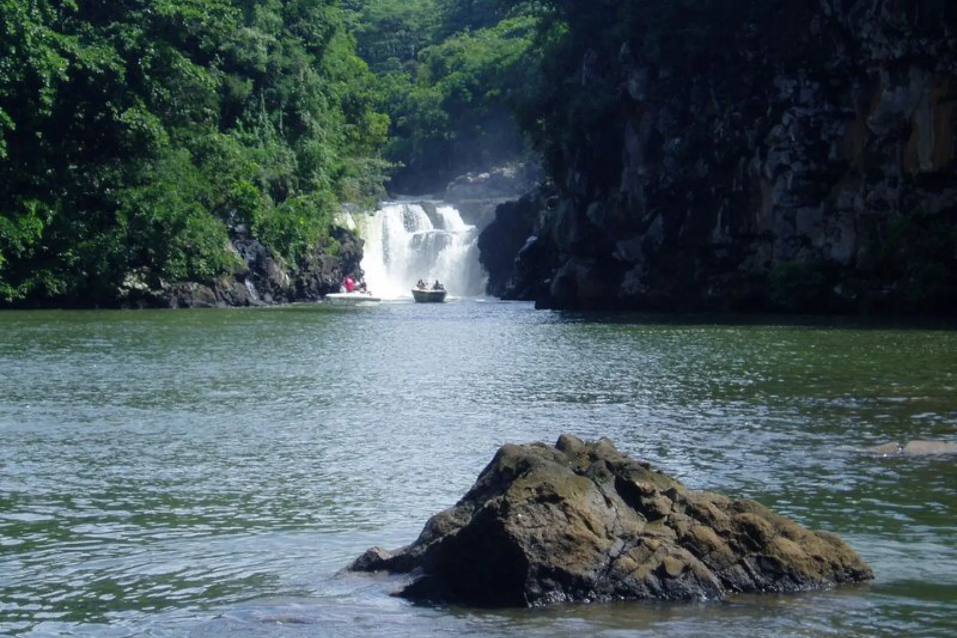 Waterfall with boats in river canyon, Mauritius