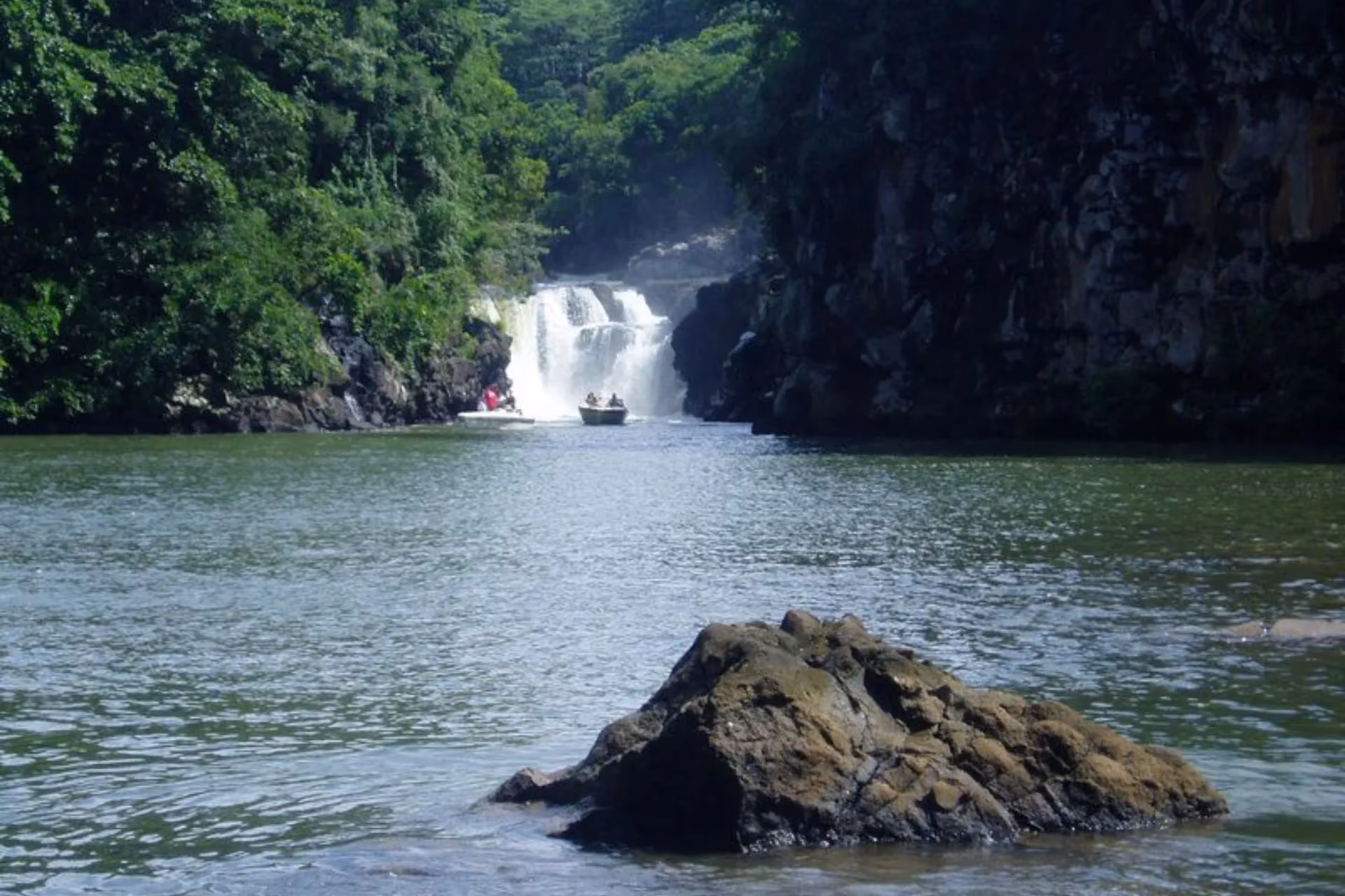 Waterfall with boats in river canyon, Mauritius