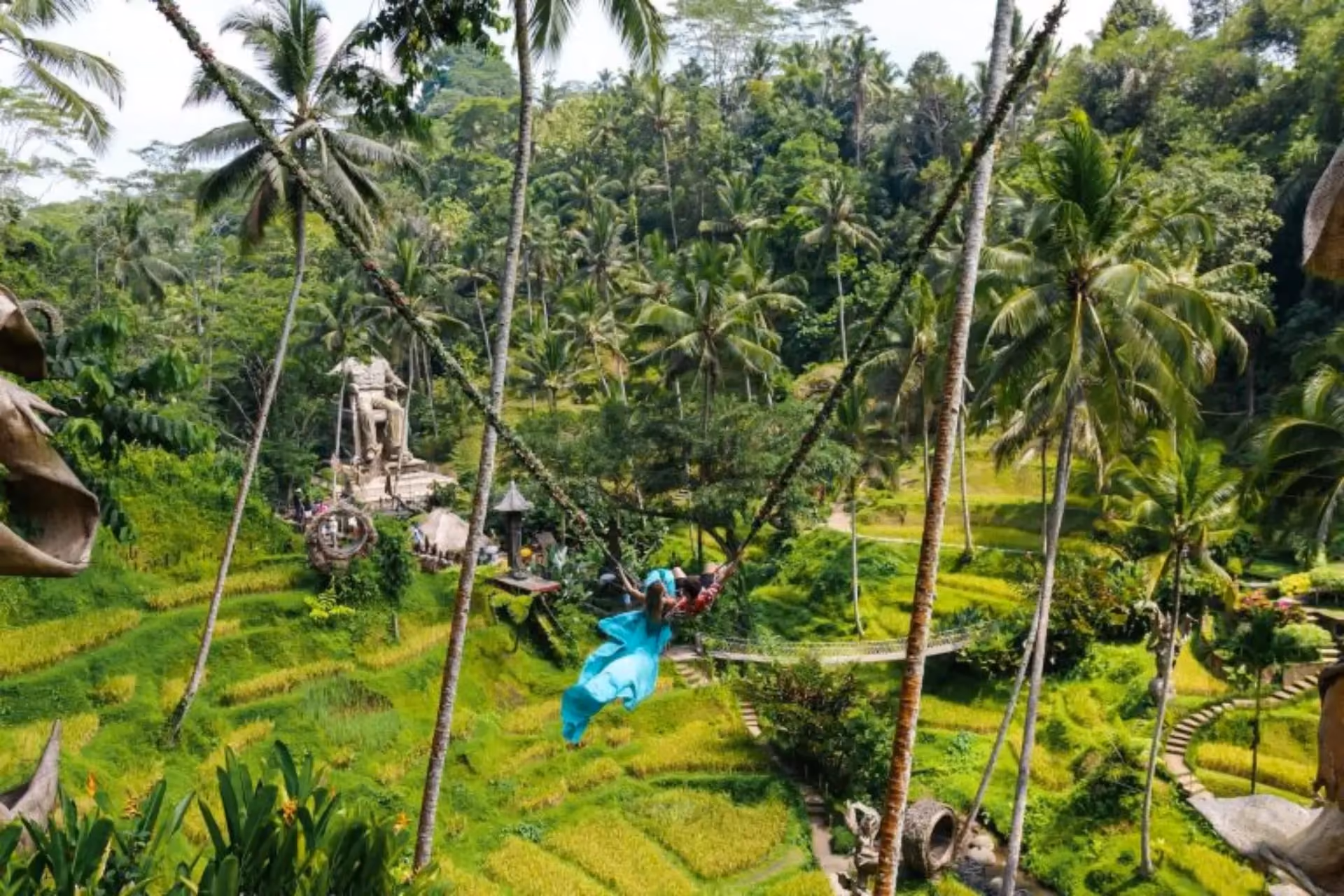 Person in blue swinging on rope at Alas Harum jungle park
