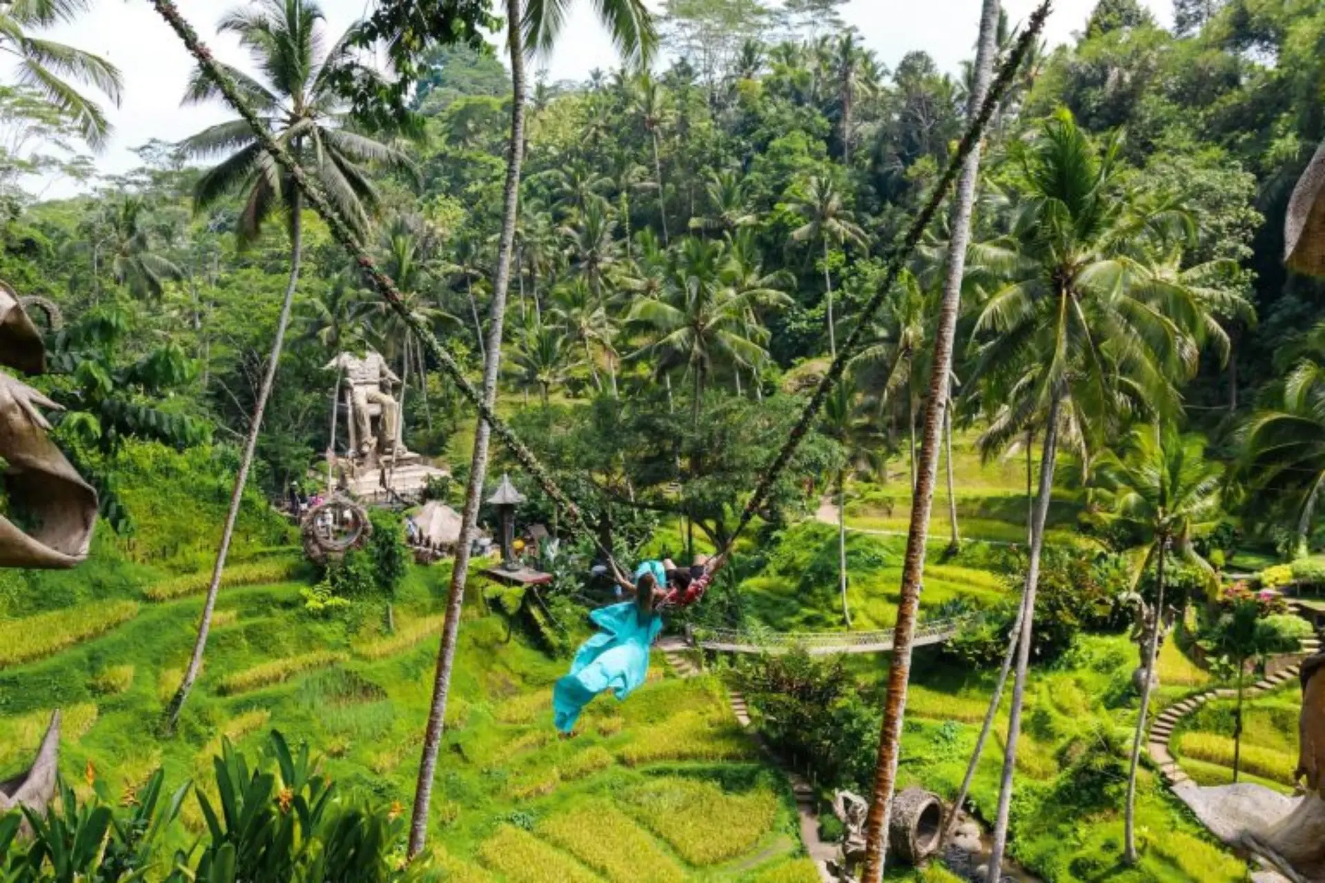 Person in blue swinging on rope at Alas Harum jungle park