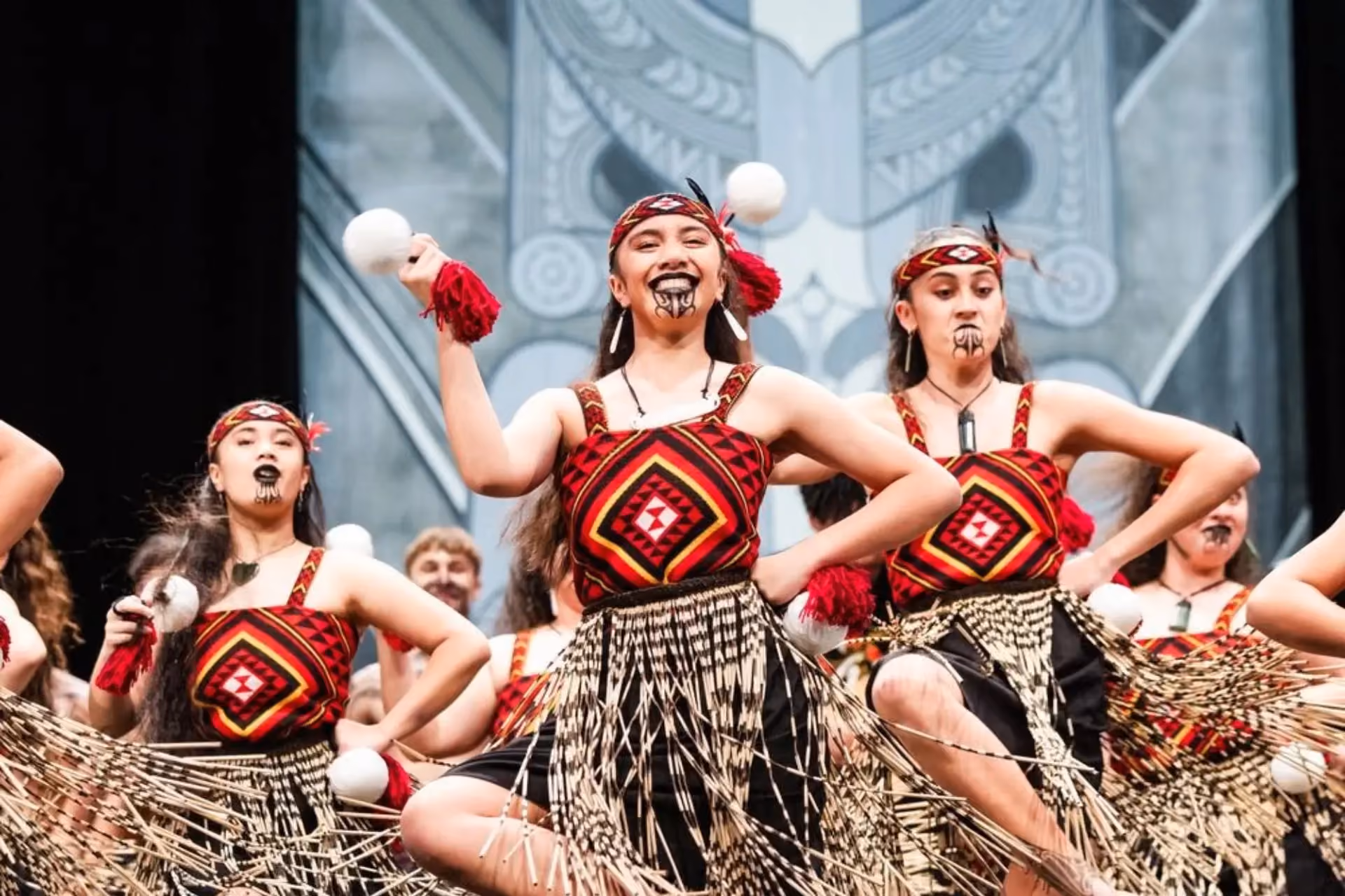 Young performers doing haka dance in New Zealand with traditional face paint