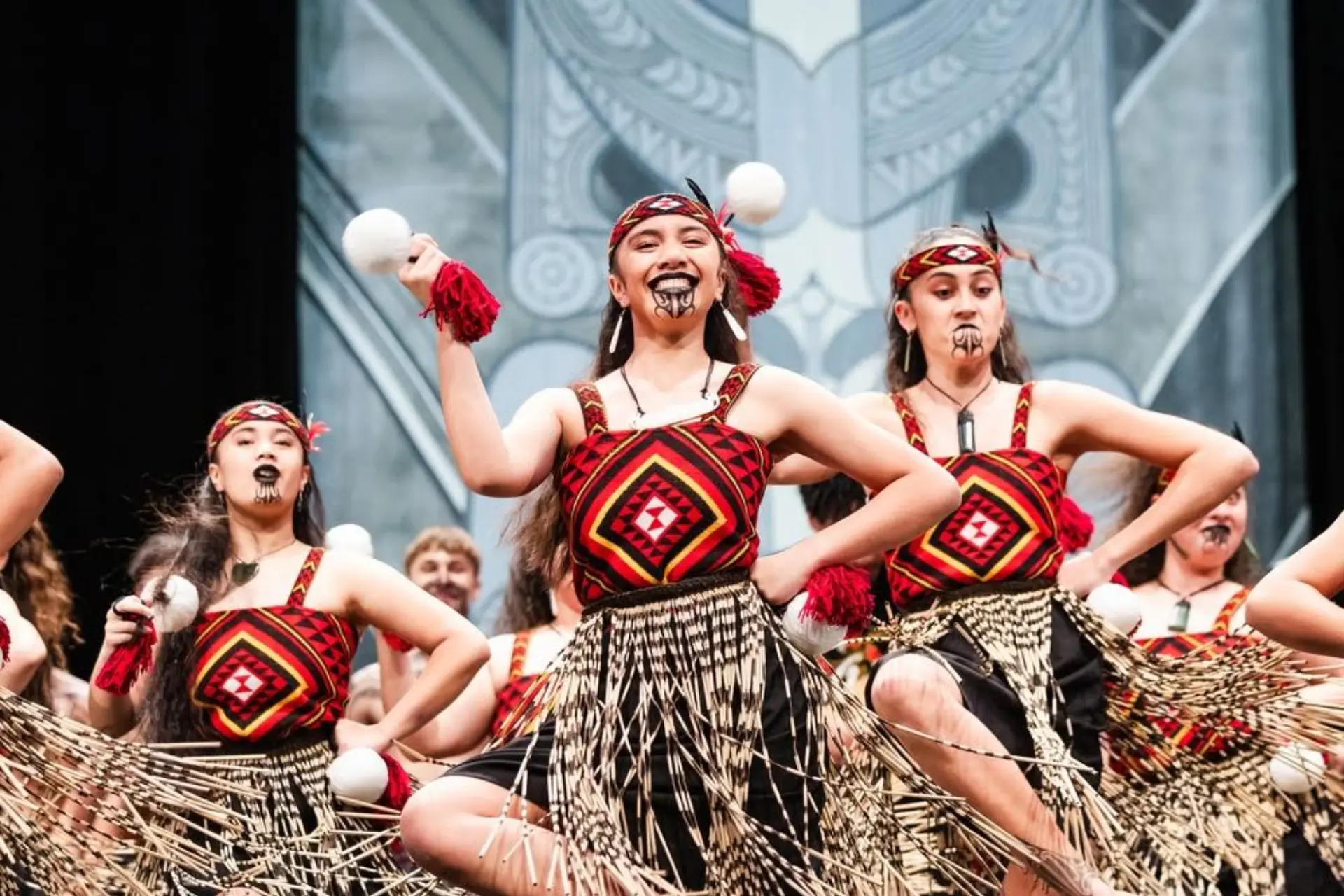Young performers doing haka dance in New Zealand with traditional face paint