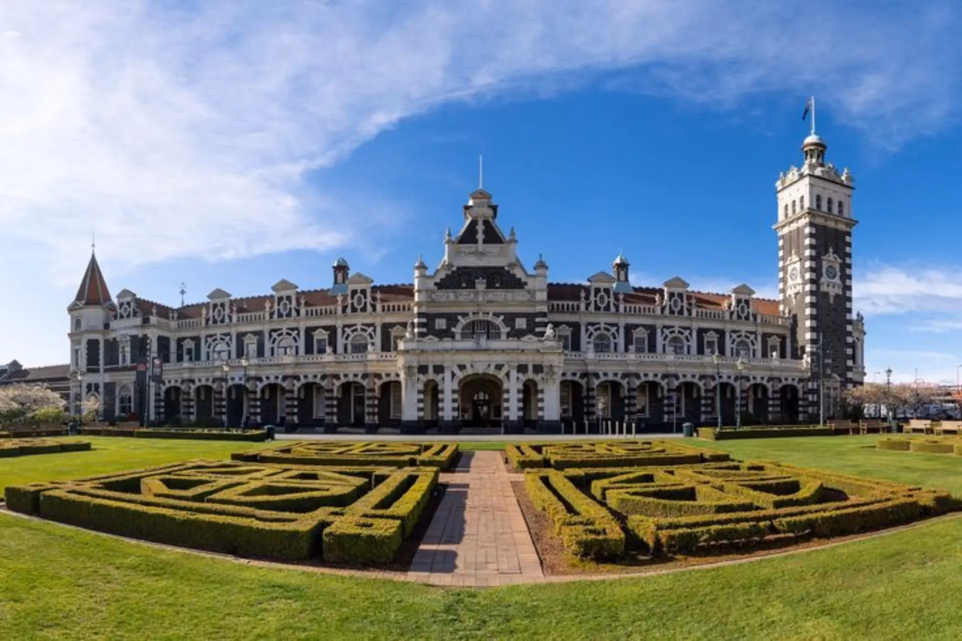 Dunedin Railway Station with formal gardens and green lawn