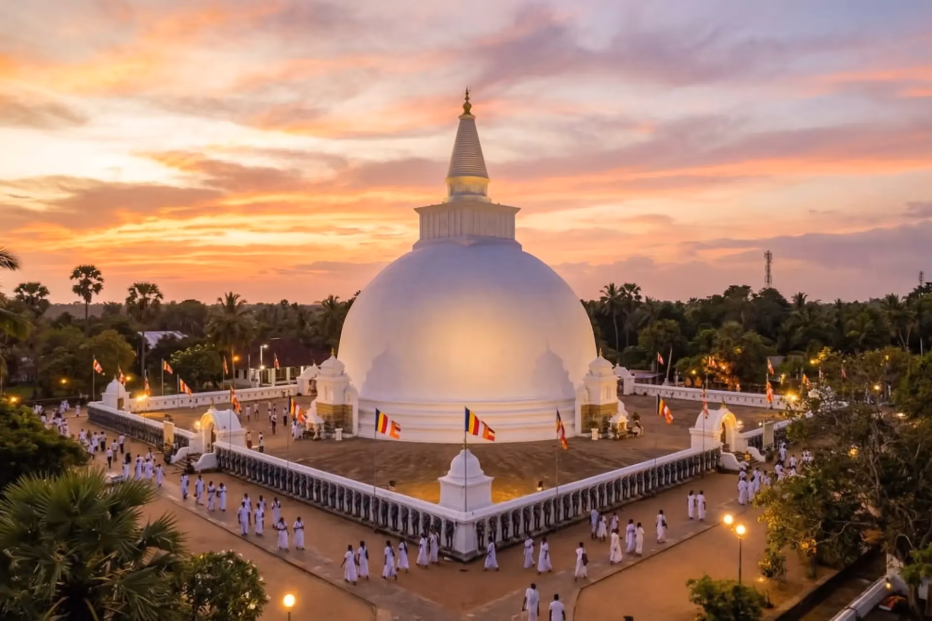White dome temple in Sri Lanka at sunset with people gathered around