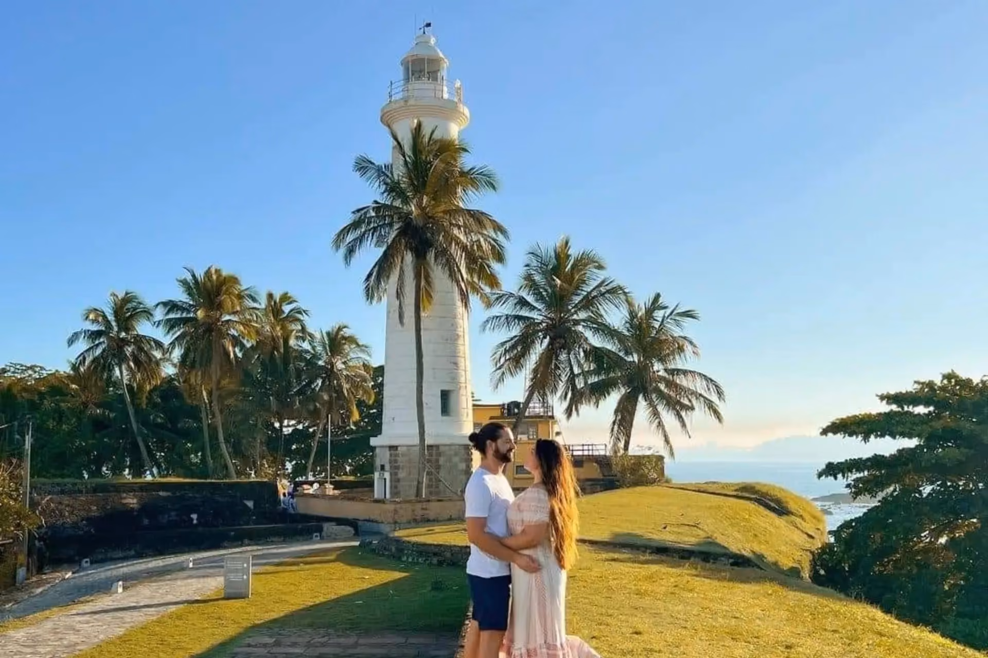 Couple at Galle lighthouse with palm trees Sri Lanka