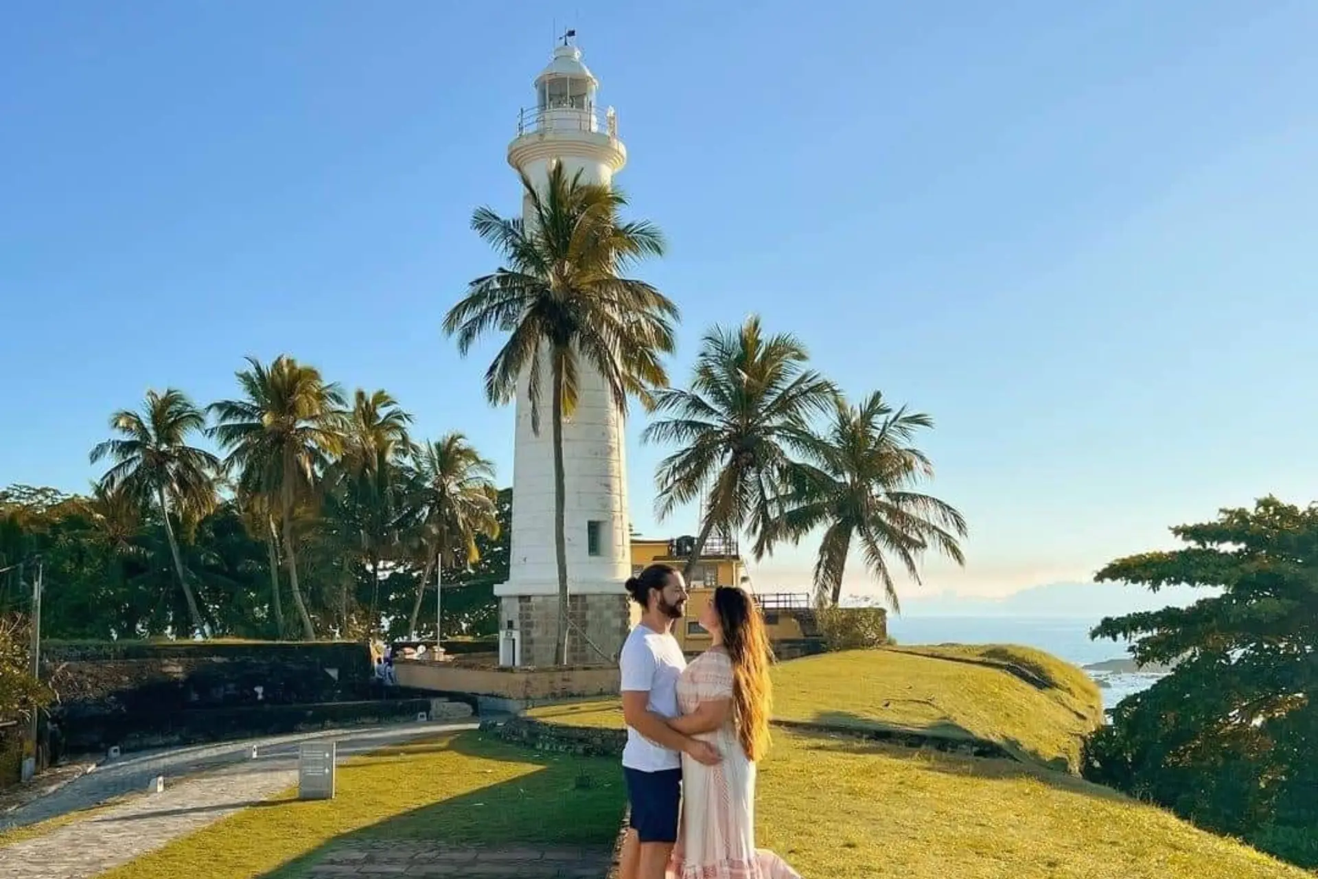 Couple at Galle lighthouse with palm trees Sri Lanka