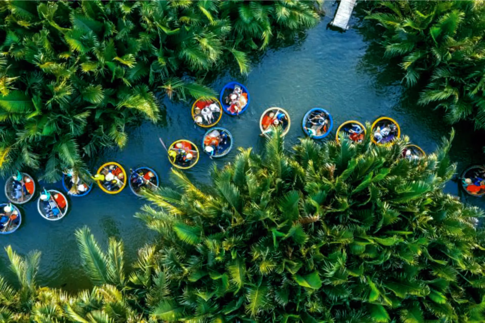 Boats with colorful roofs float on blue water in Coco Forest