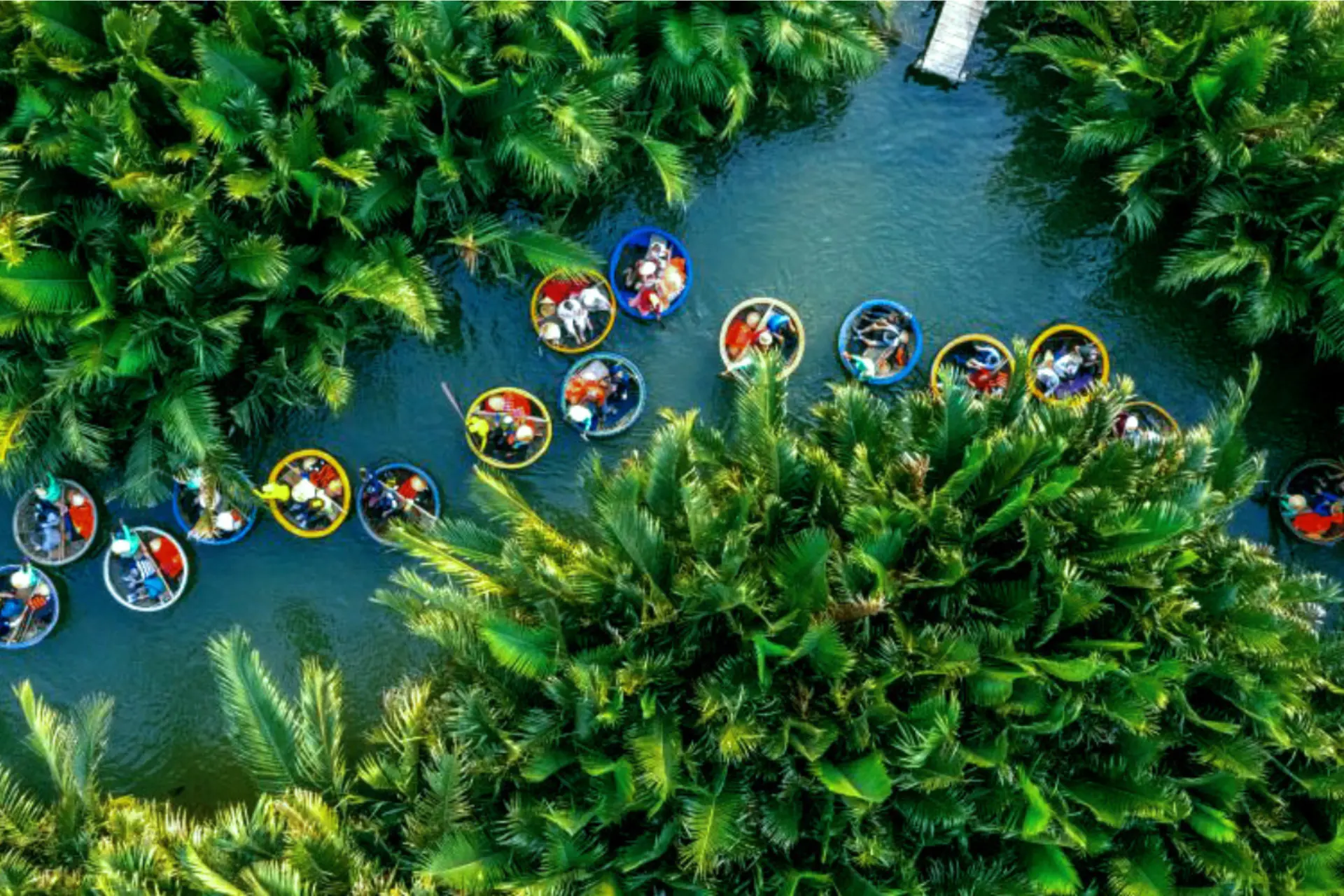 Boats with colorful roofs float on blue water in Coco Forest