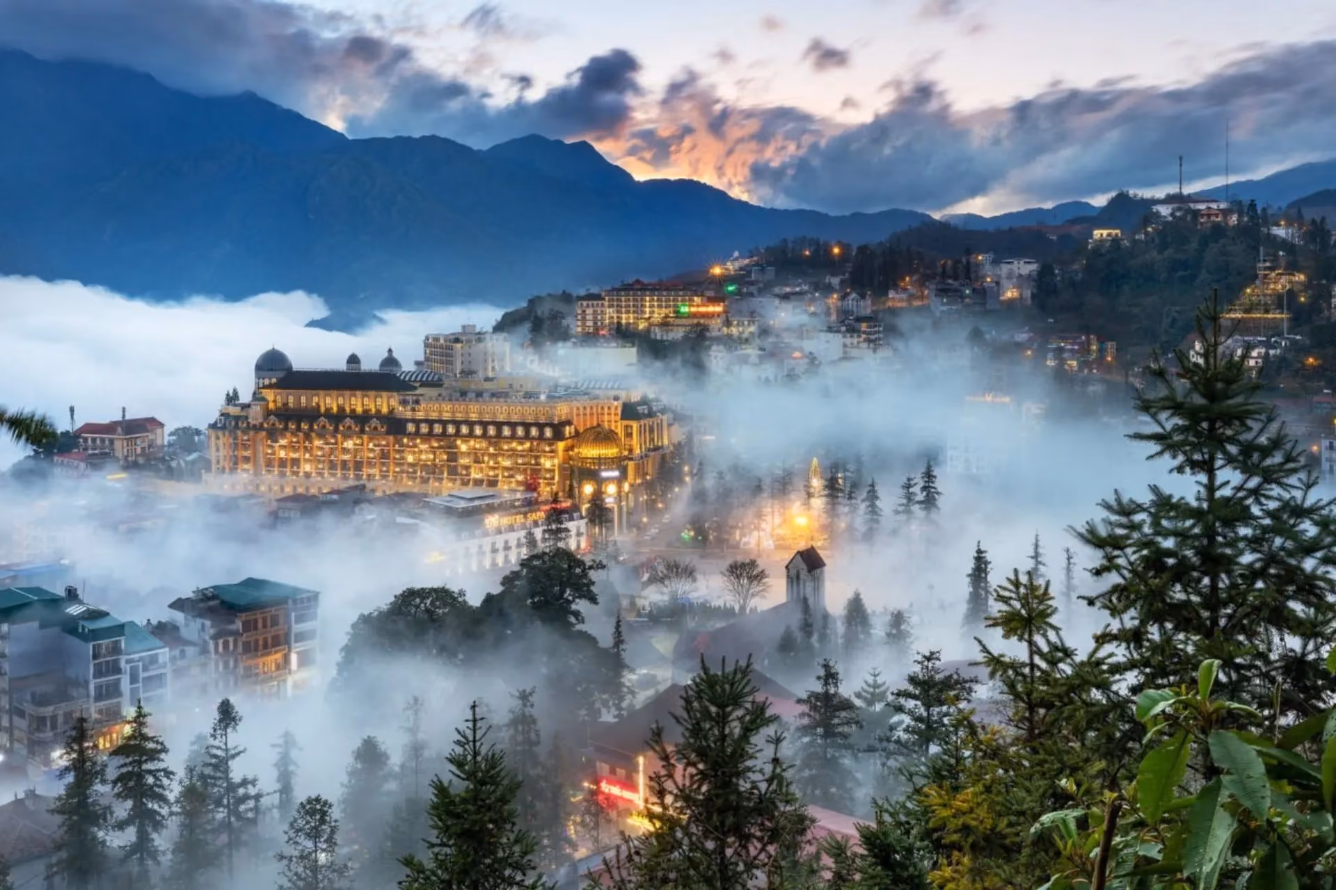 Sapa Vietnam town glowing through thick morning fog and mountains