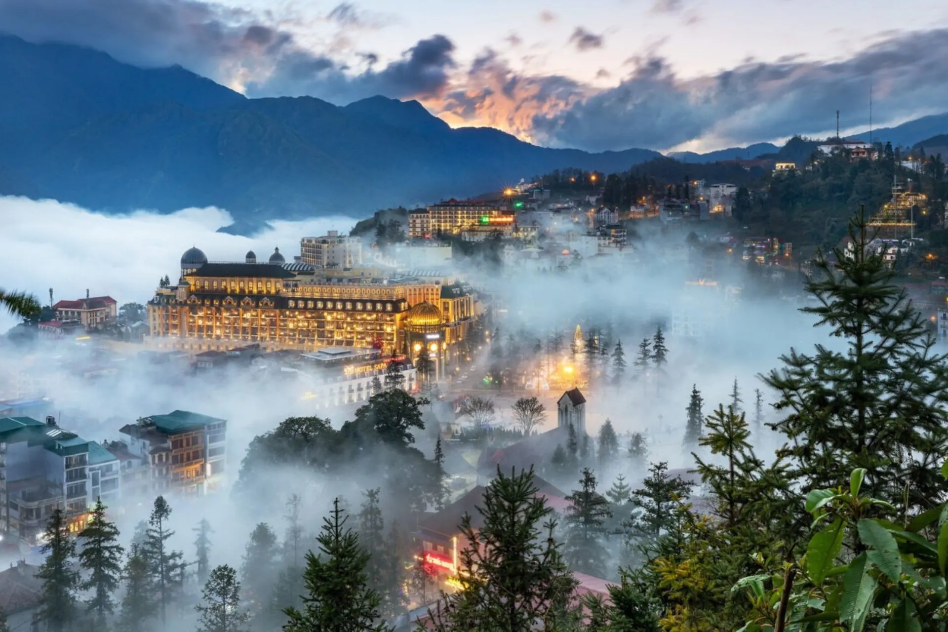 Sapa Vietnam town glowing through thick morning fog and mountains