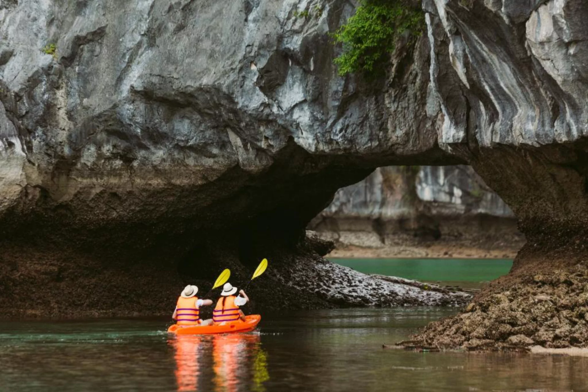 Two people kayaking under rock arch at La Regina